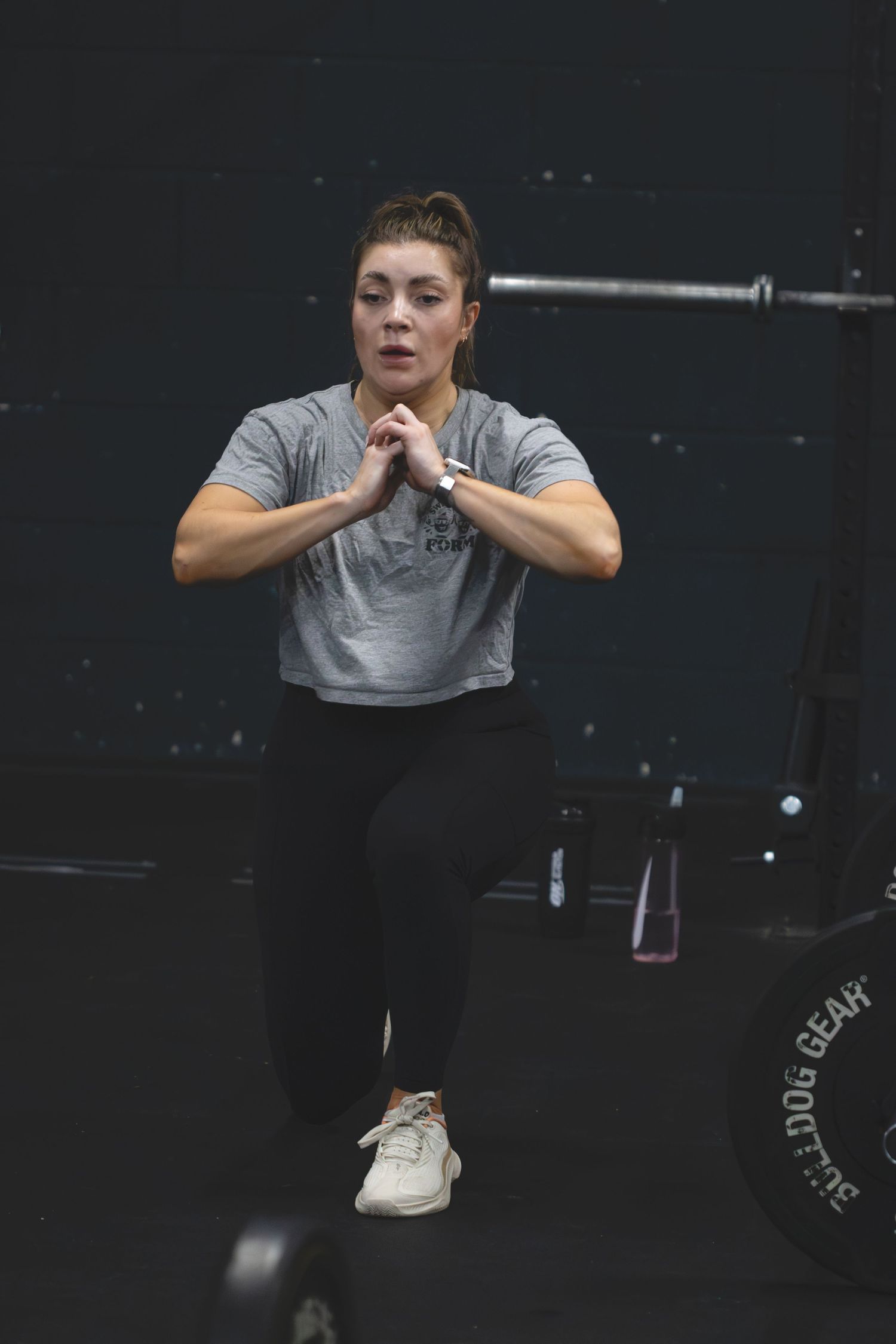 Strong athlete performs an impressive toes-to-bar exercise at a dark CrossFit gym.