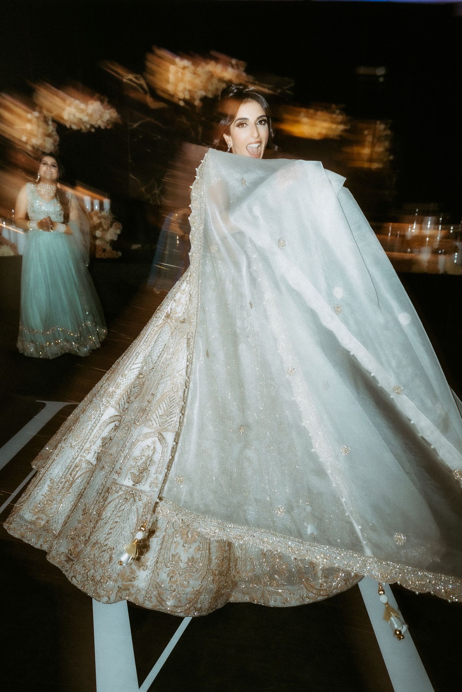 A flowing white wedding dress with delicate lace details spins and twirls in a series of motion-blurred photographs.