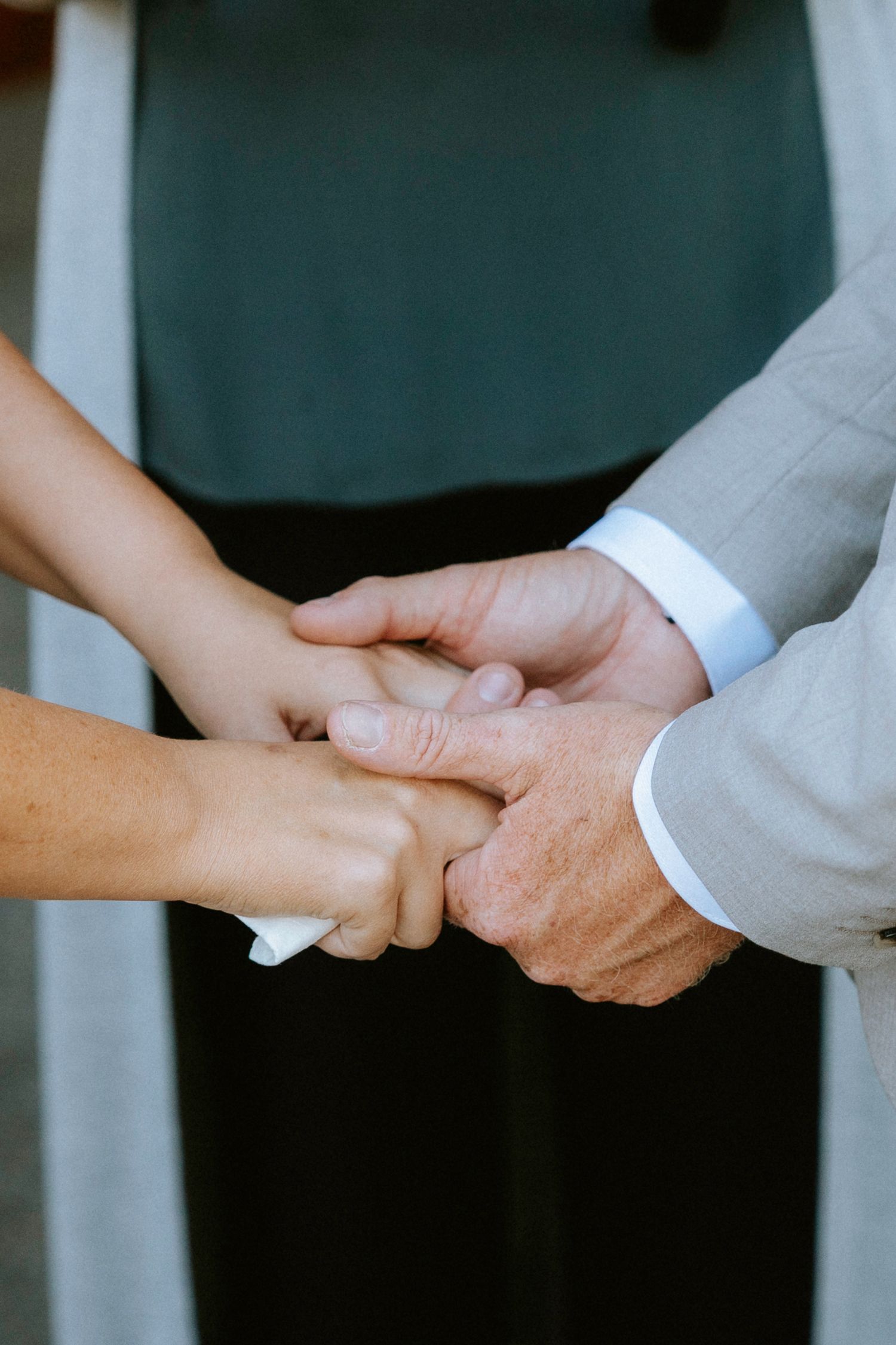 Series of close-up shots showing hands clasped together in an emotional wedding ceremony moment.