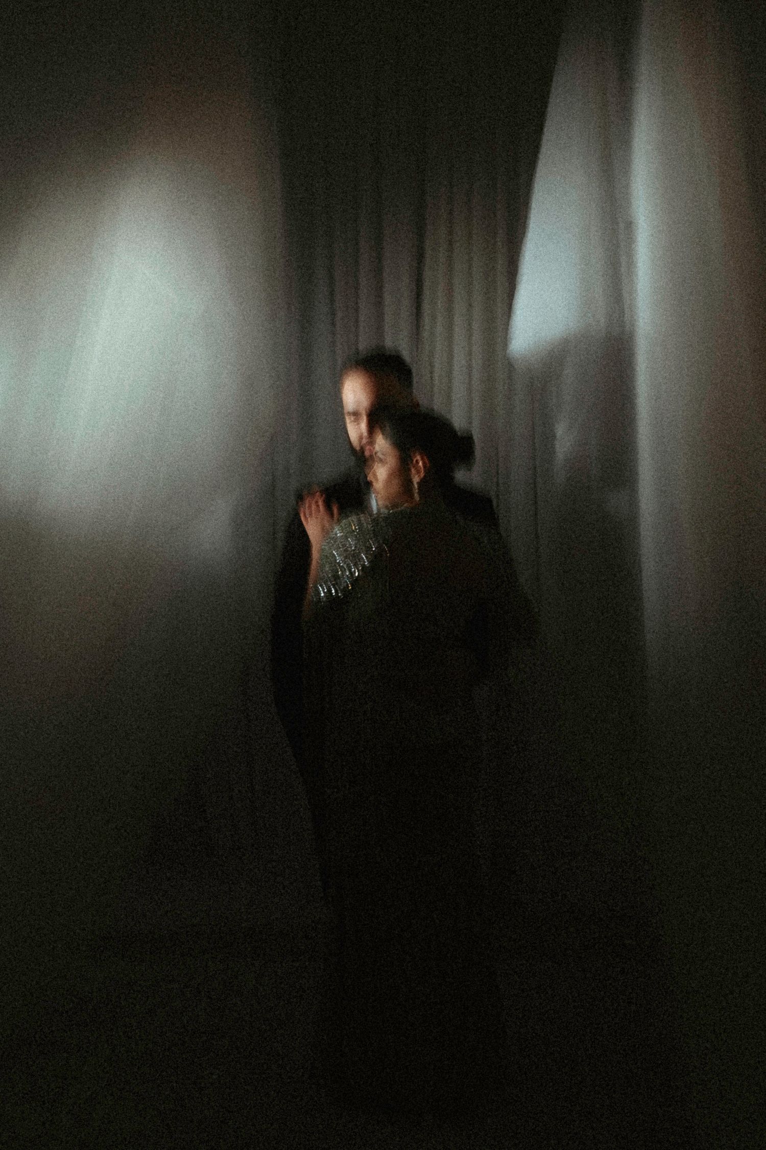 A dark and moody sequence of four silhouetted figures against a dim background in dramatic lighting.
