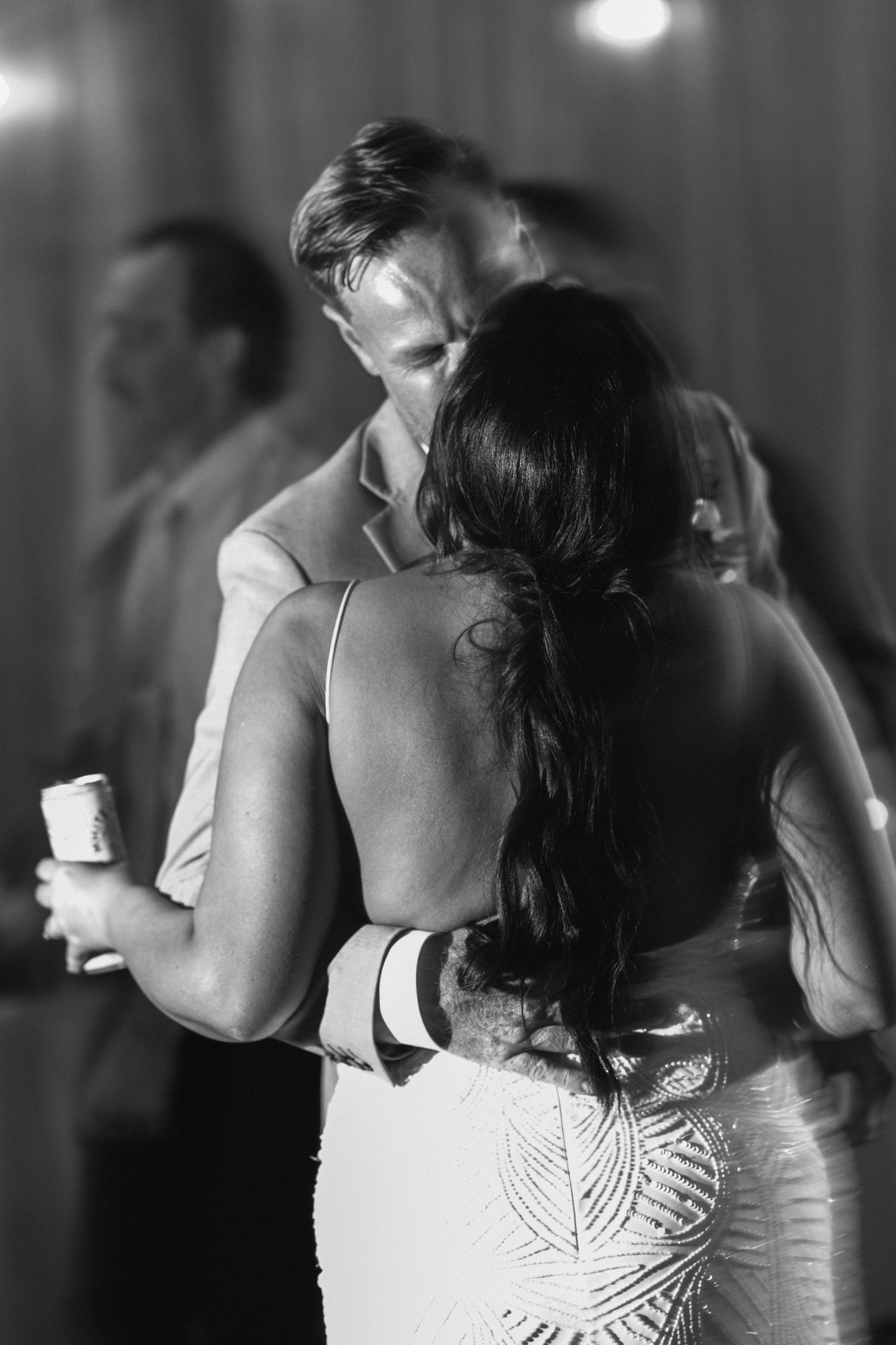 Black and white photo showing intricate beaded details on the back of a formal dress.