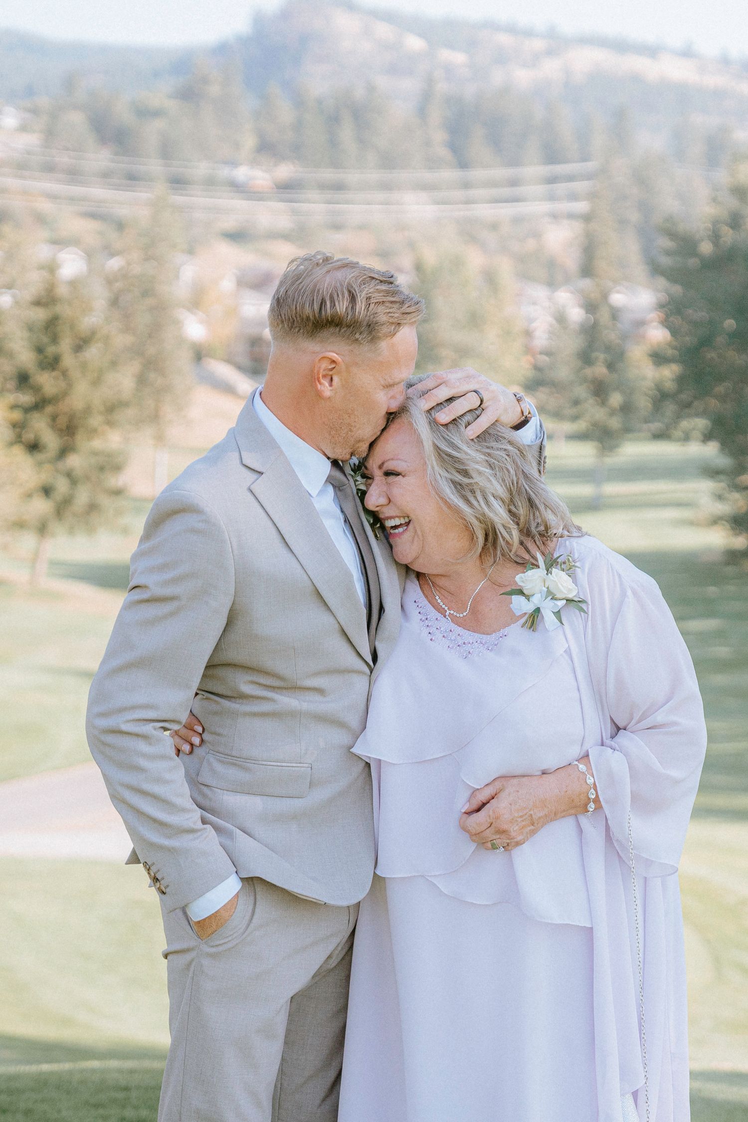 Joyful couple shares candid laughing moments during their outdoor wedding photoshoot.