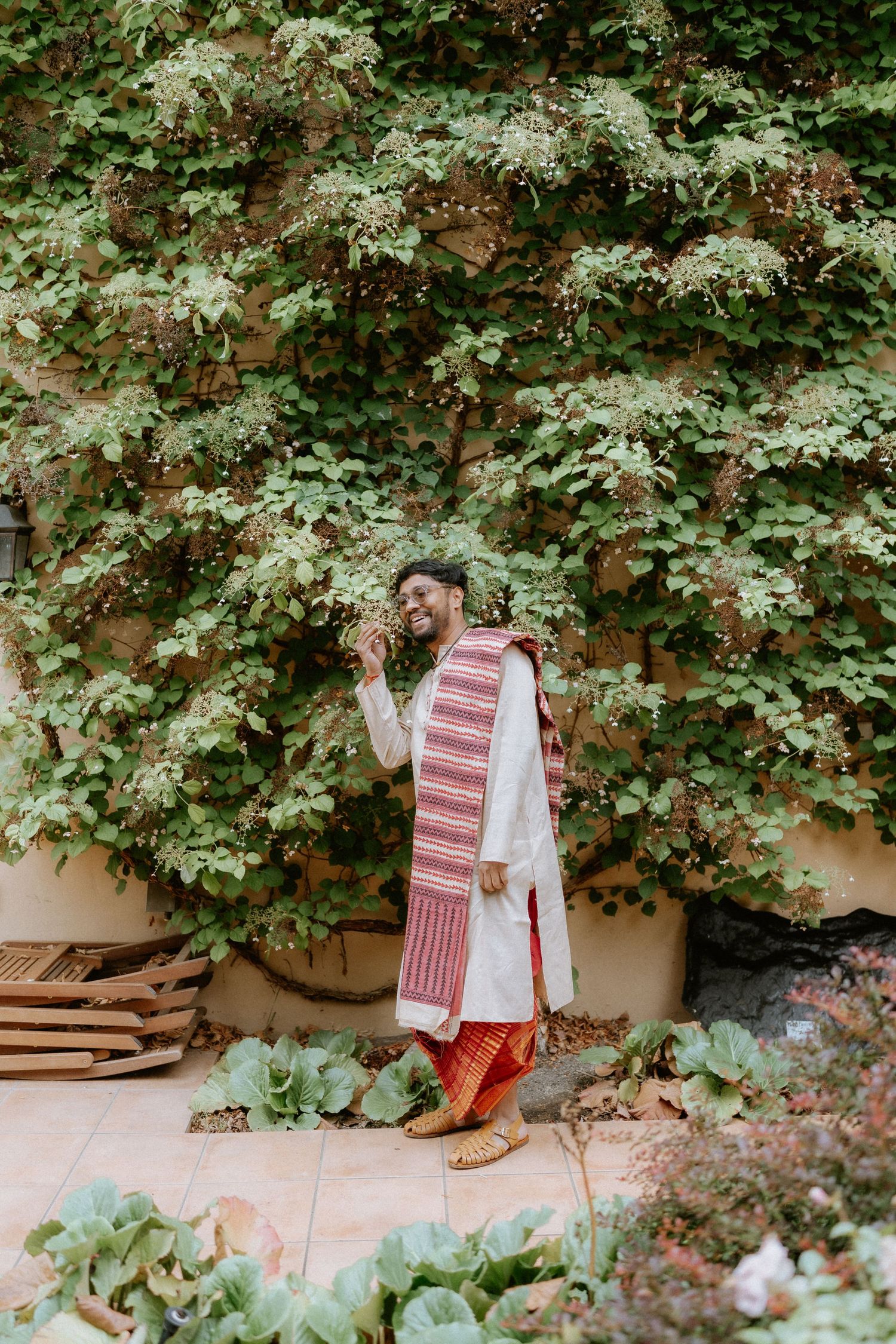 Traditional red and white striped textiles displayed in a lush garden setting.
