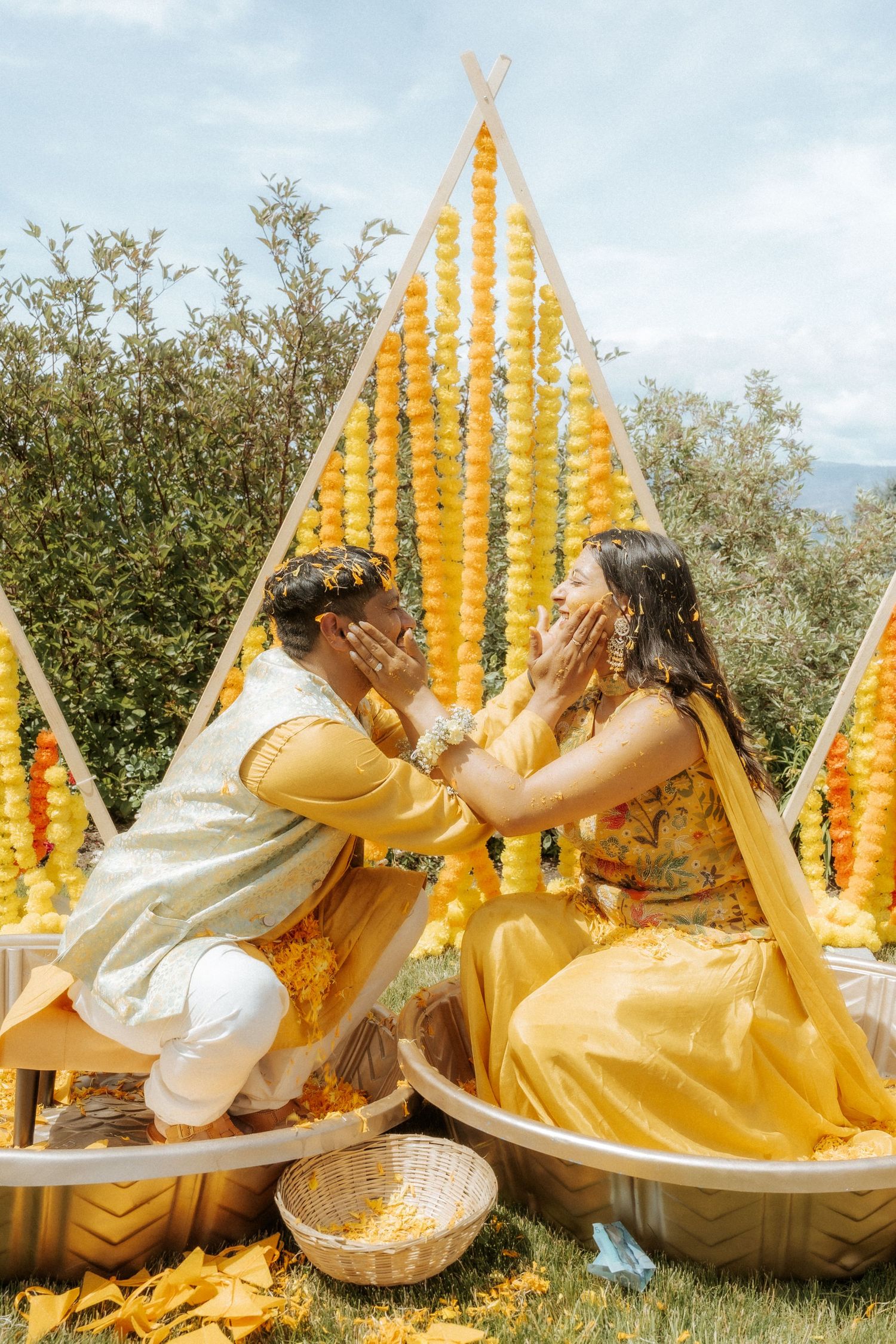 Traditional Indian pre-wedding Haldi ceremony setup outdoors with yellow marigold garlands and festive decor in nature.