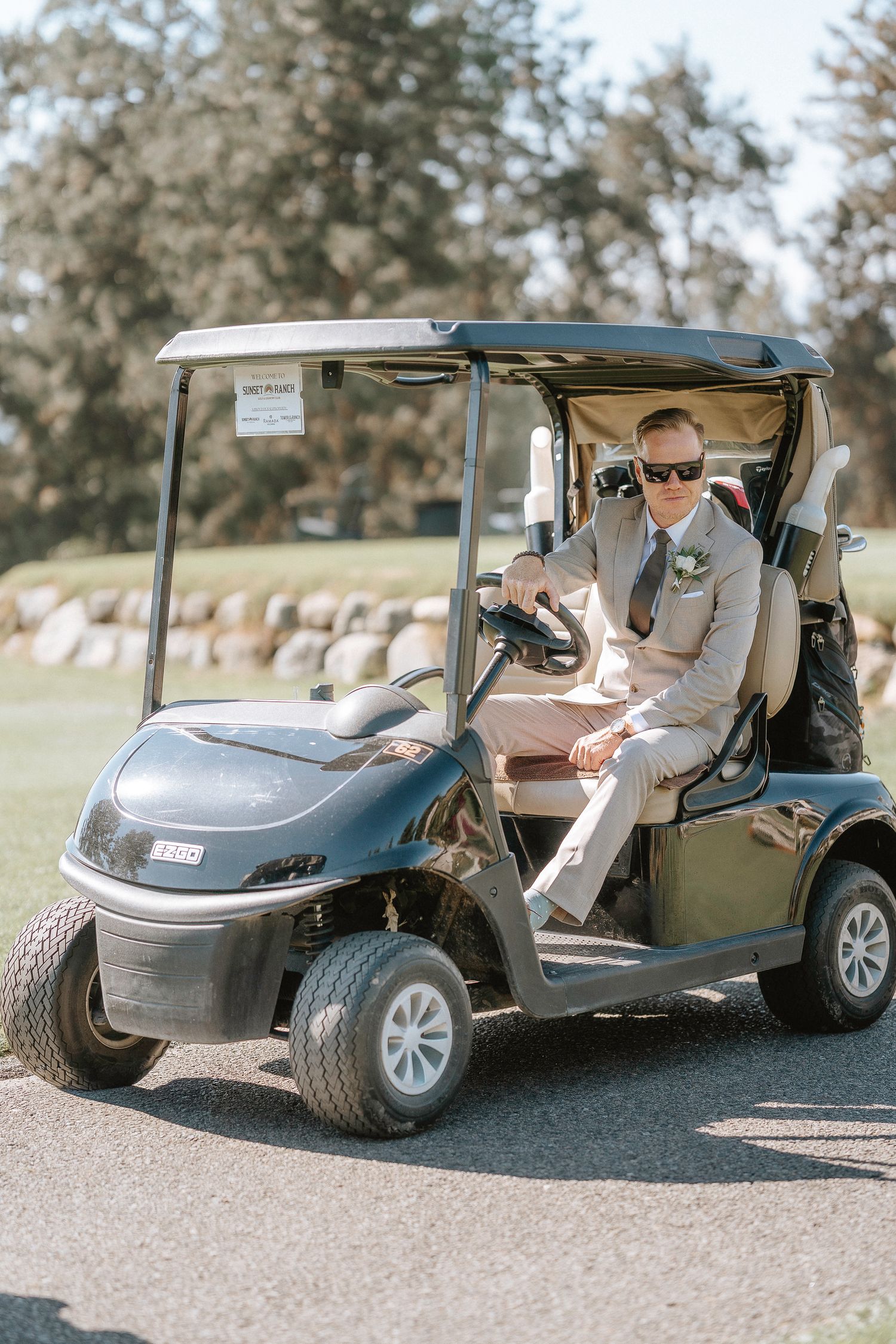 Golf carts lined up on a path at an outdoor wedding venue.