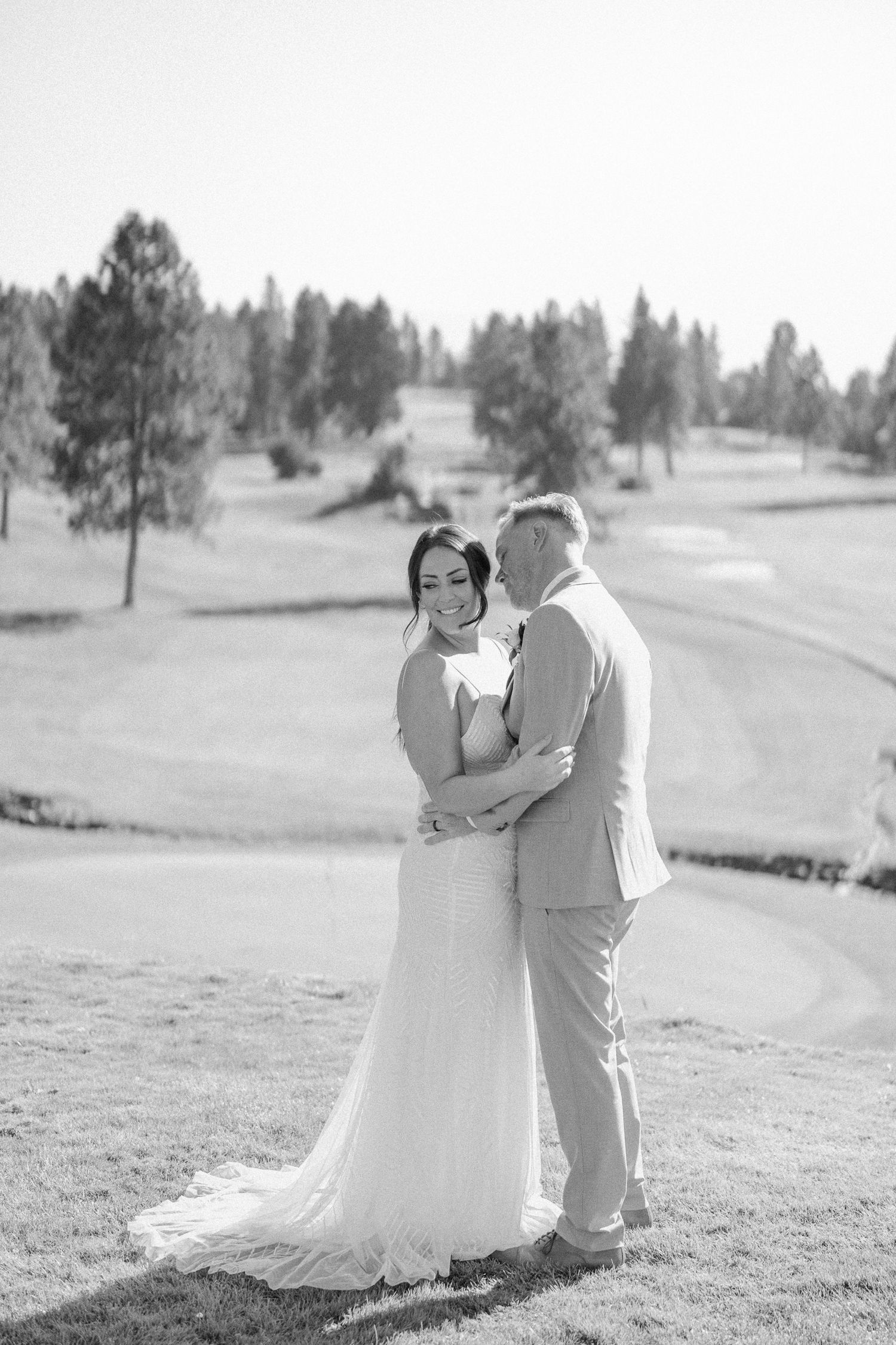A couple shares romantic moments on a sunny golf course in a series of candid wedding photos.