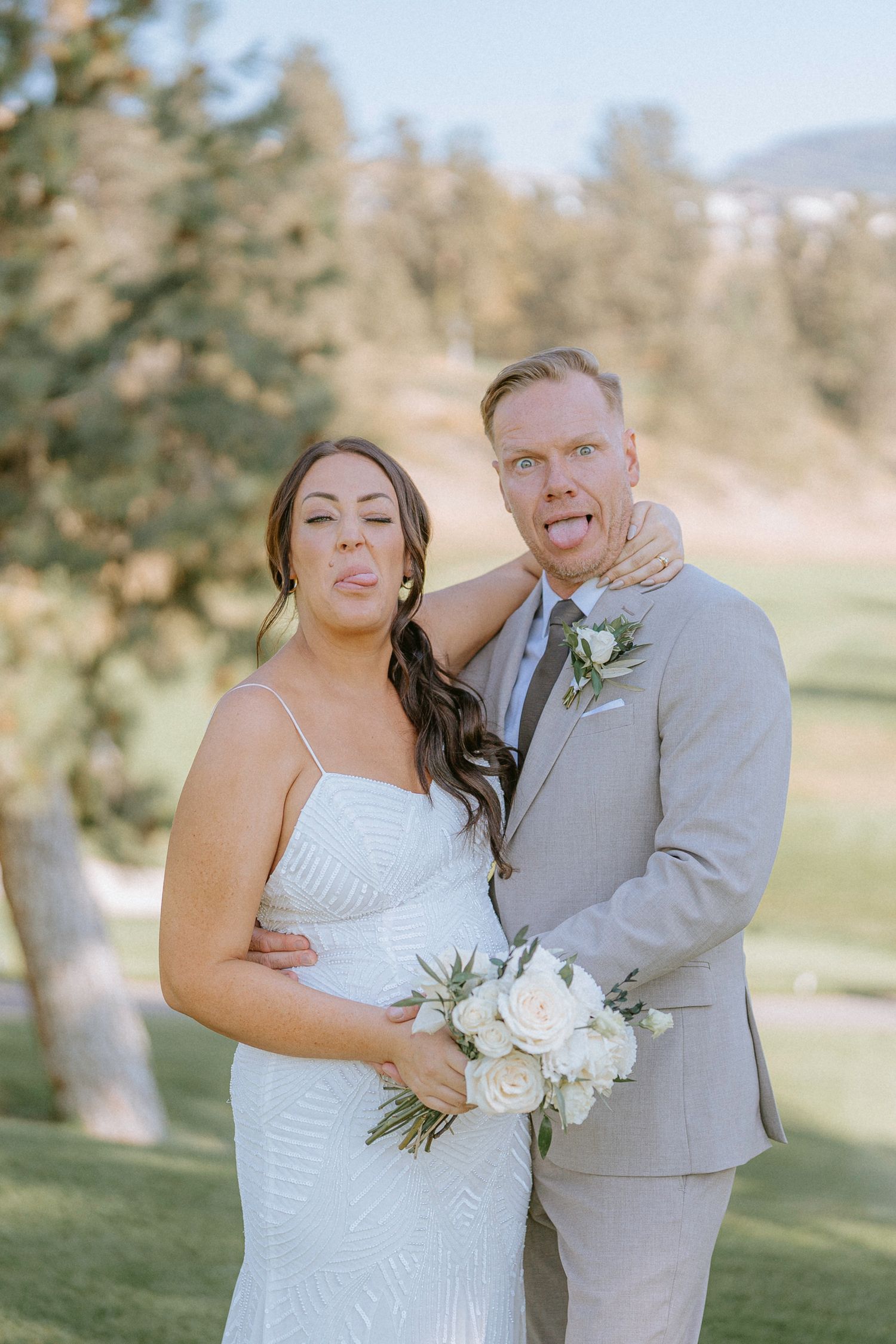 A couple shares joyful moments during their wedding photoshoot on a scenic golf course.
