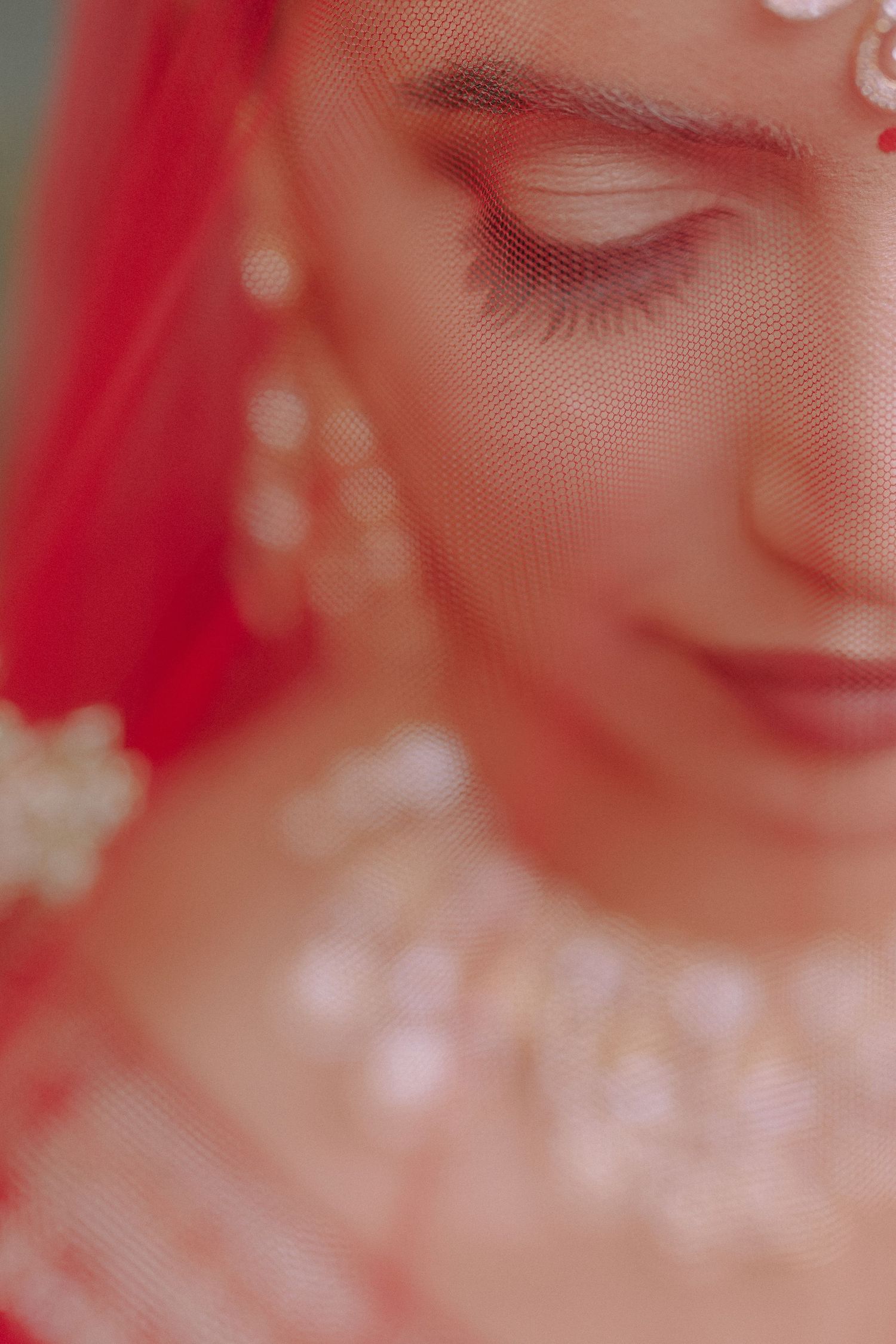 Close-up portrait with soft pink lighting and dreamy bokeh effect creating a romantic ethereal atmosphere.