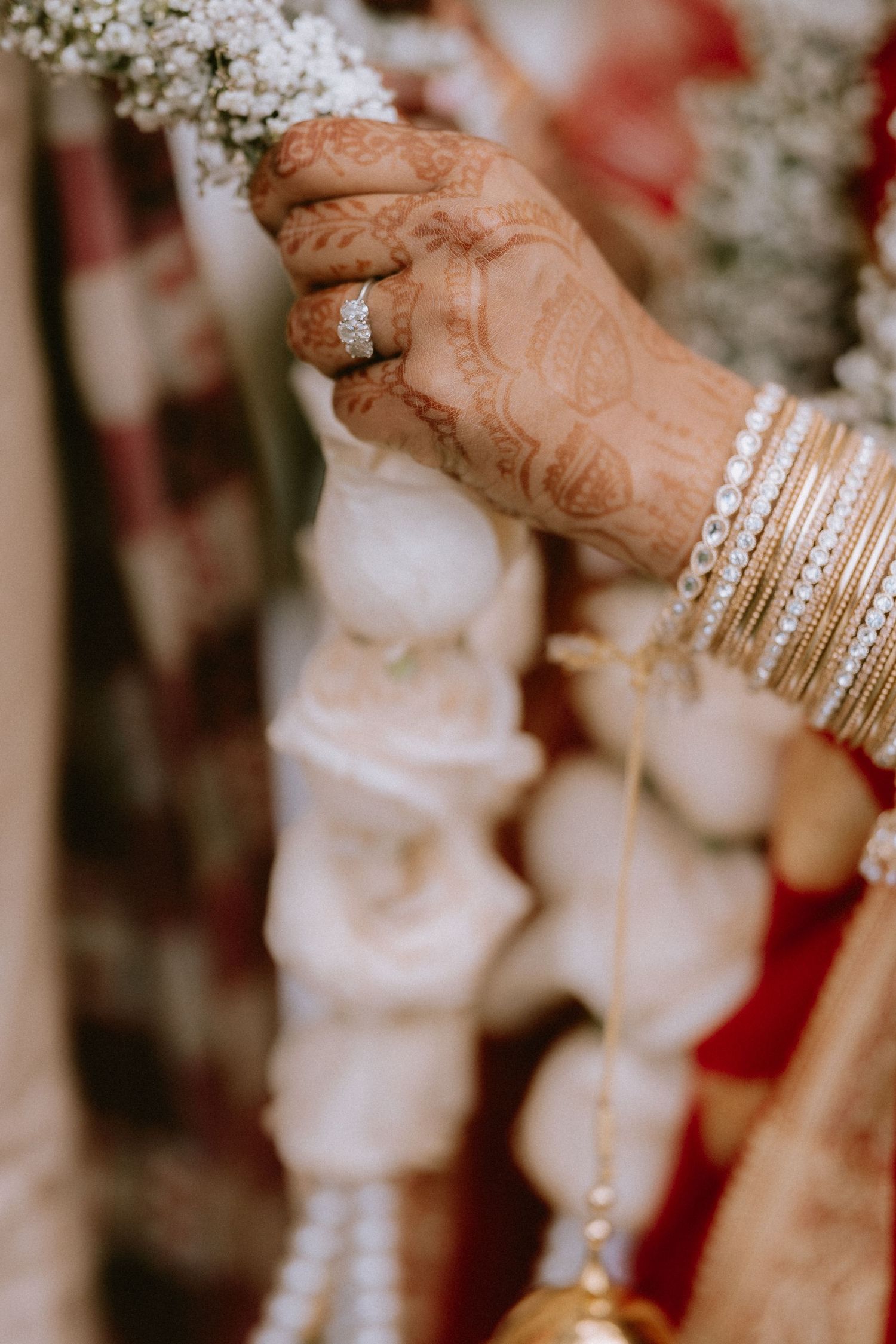 Close-up shot of hands adorned with traditional Indian bangles and mehndi designs.