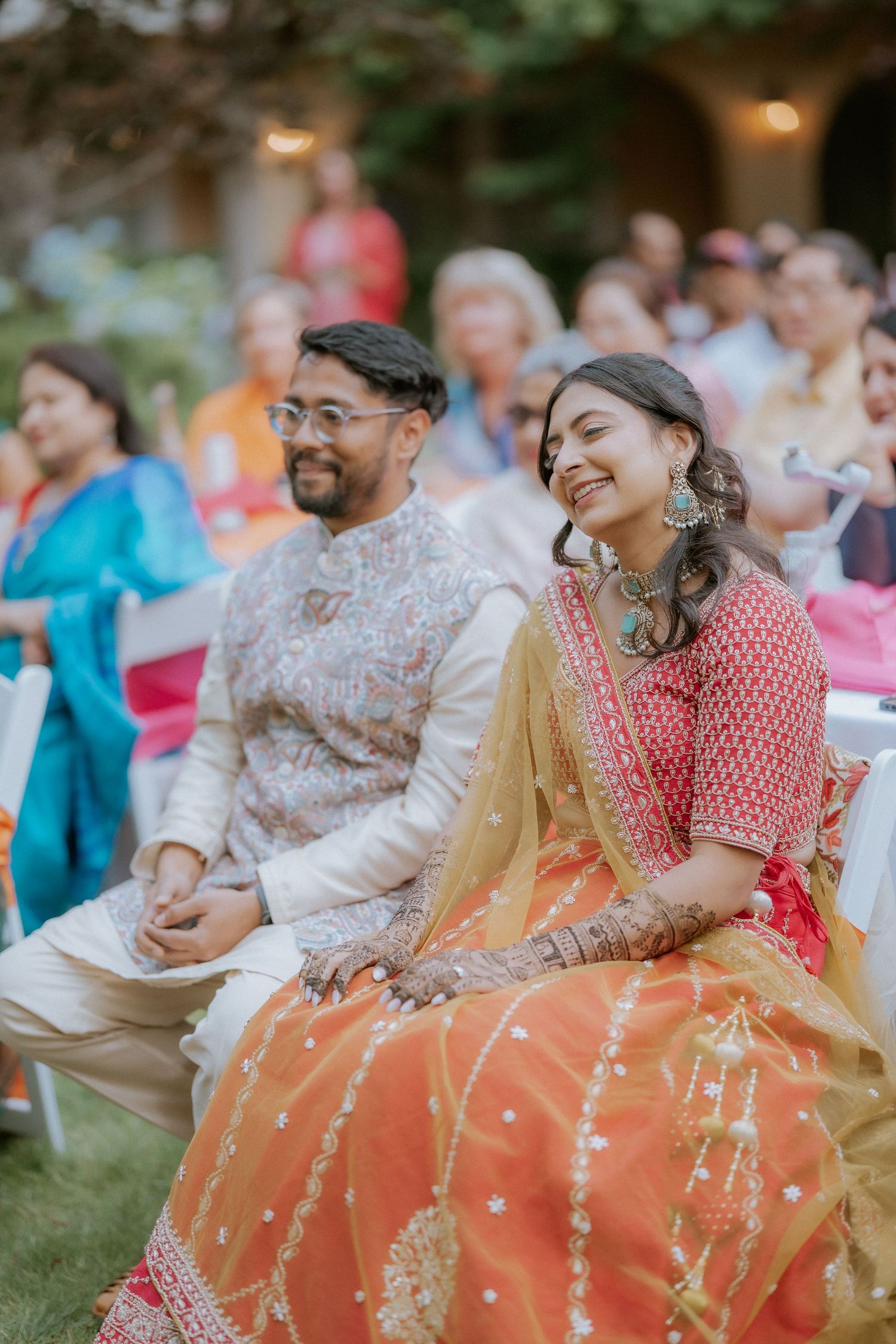 Guests enjoying a joyful outdoor celebration with colorful traditional attire and decorations.
