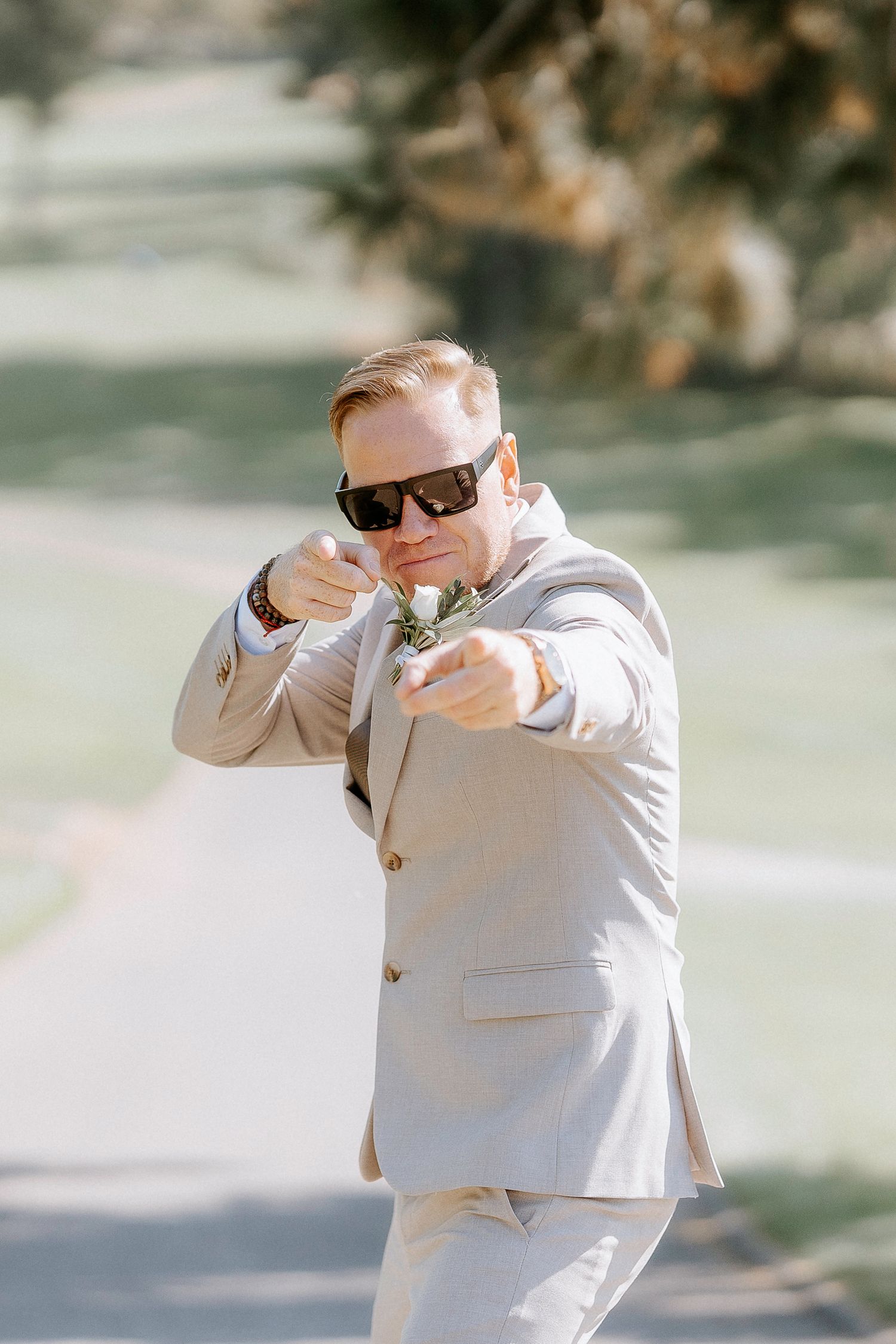 A series of playful dabbing poses in light colored formal attire against a bright outdoor background.
