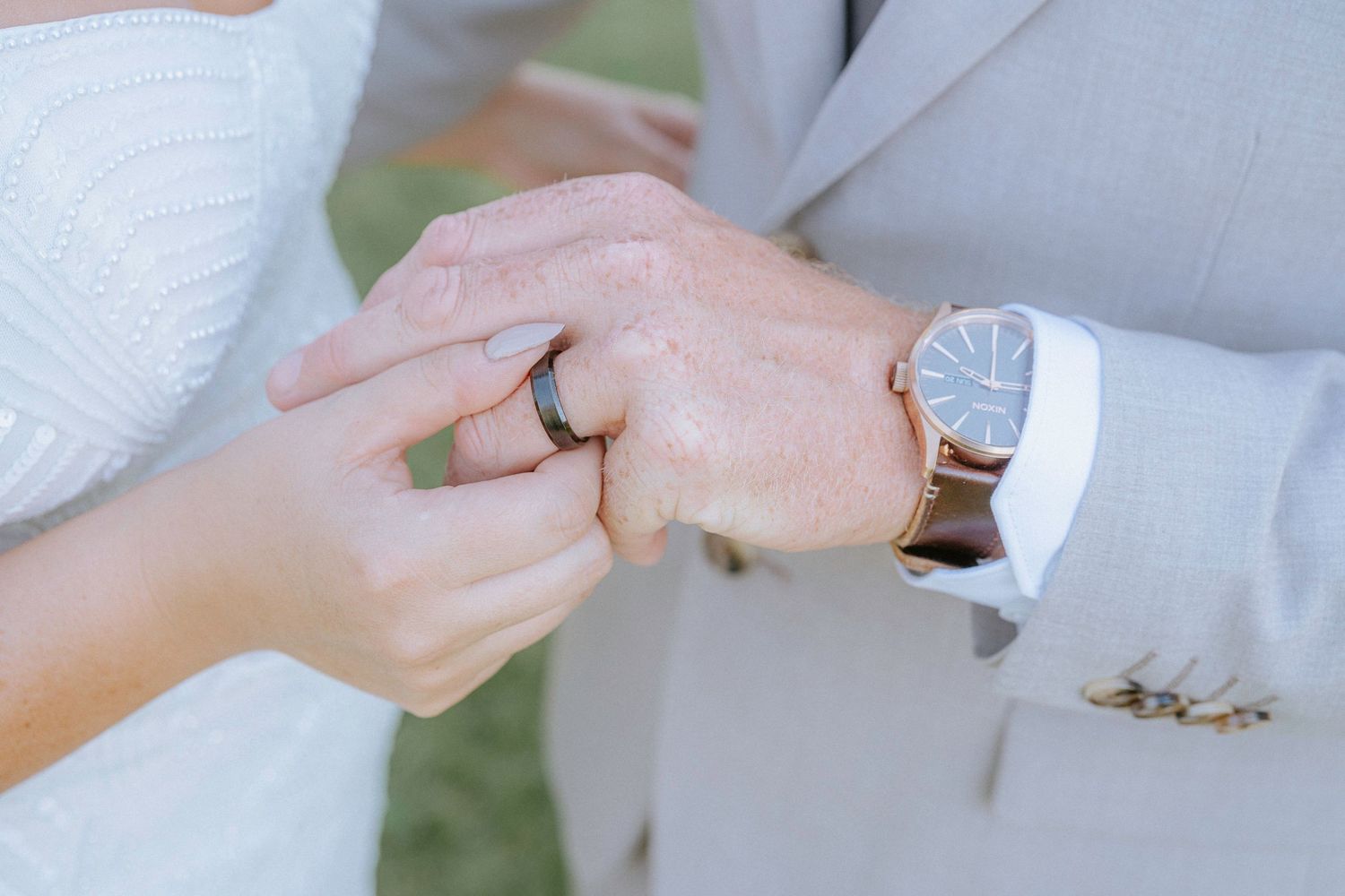 Close-up shots of wedding rings being exchanged during the ceremony.