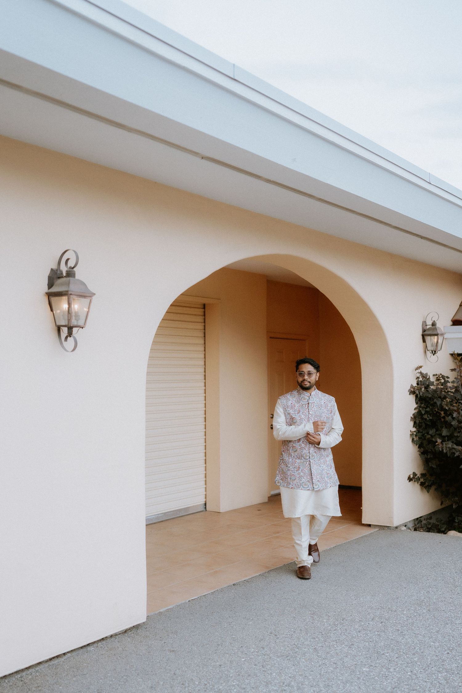 A sequence of photos showing someone in white clothing sitting and posing in front of an arched hallway entrance.