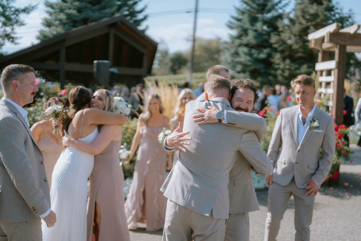 Wedding party celebrating and embracing outdoors.