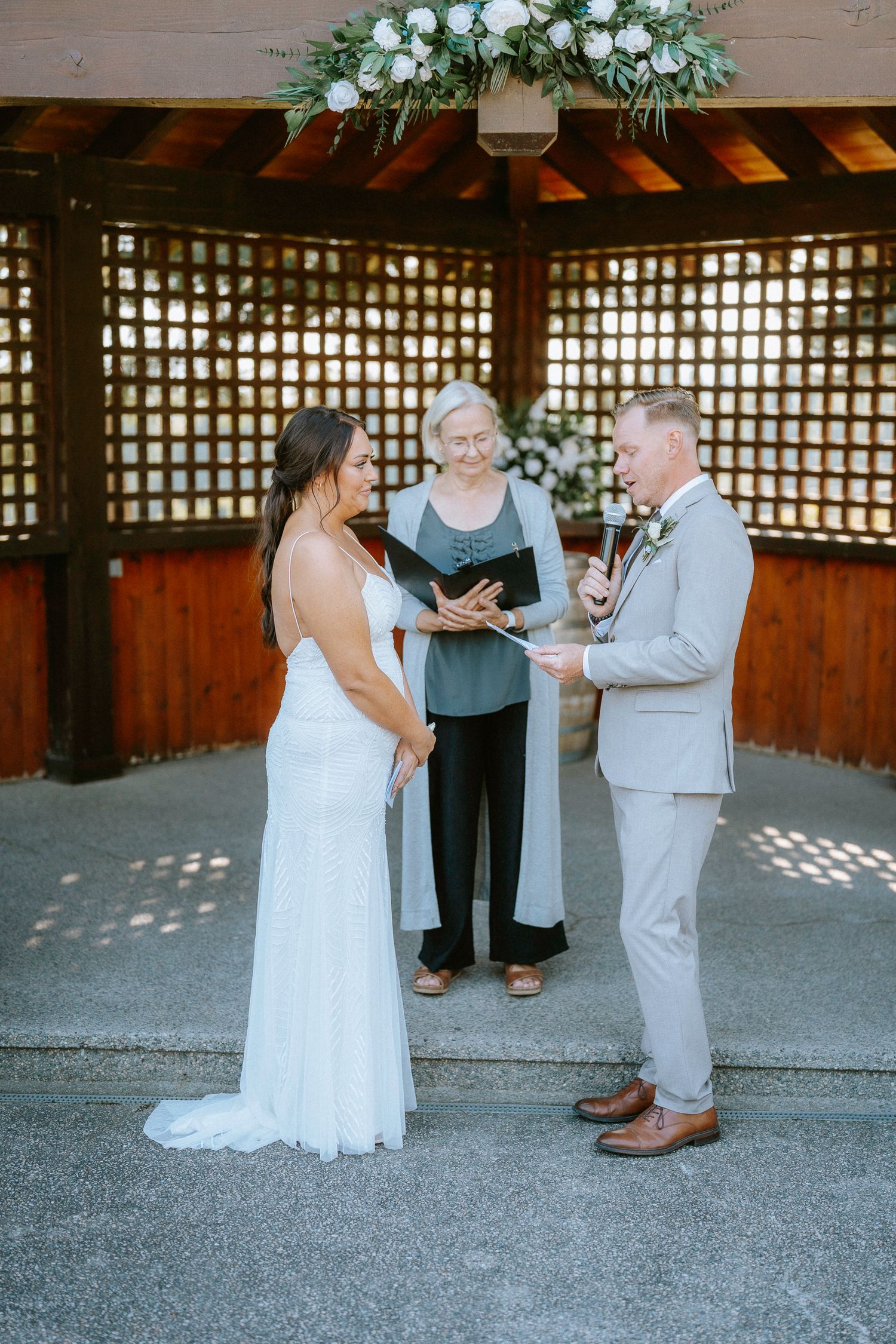 Intimate wedding ceremony moment under a wooden pergola.