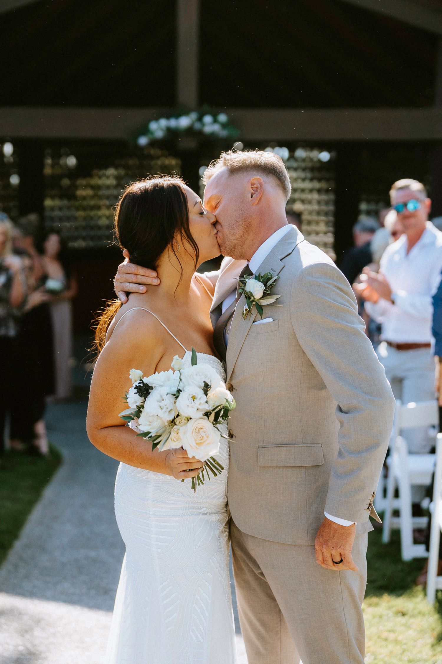 Newlyweds share their first dance outdoors at a summer wedding reception.
