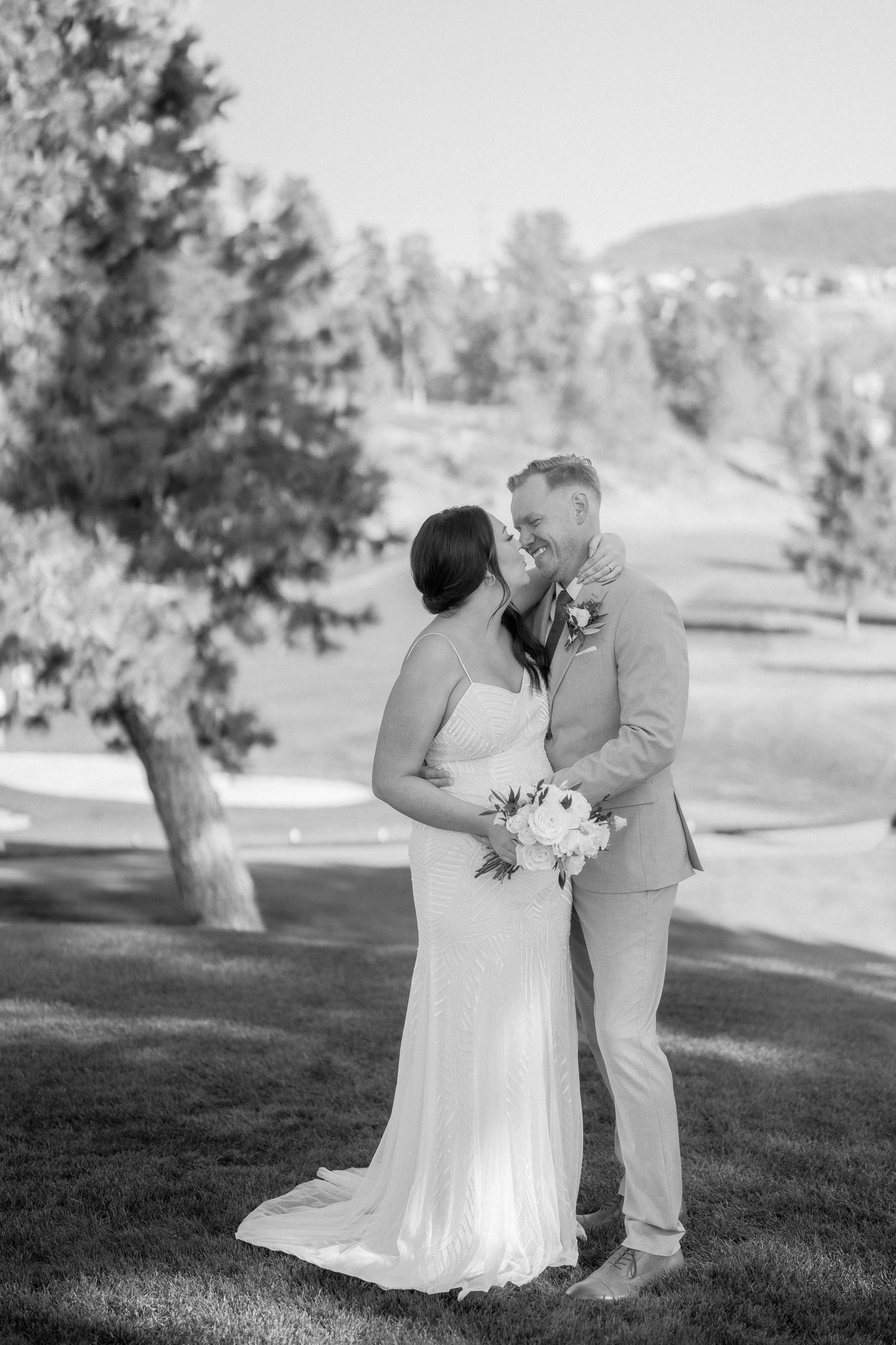 A romantic black and white wedding photo series captured on a scenic hillside.