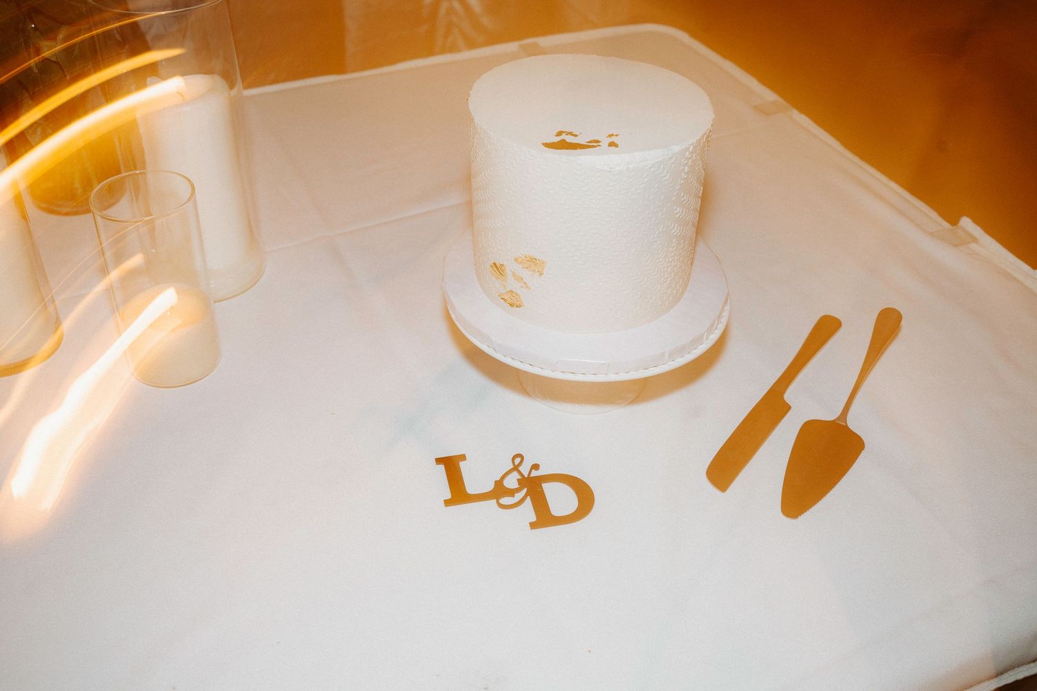 Wedding cake details photographed in warm lighting showing metallic decorative elements.