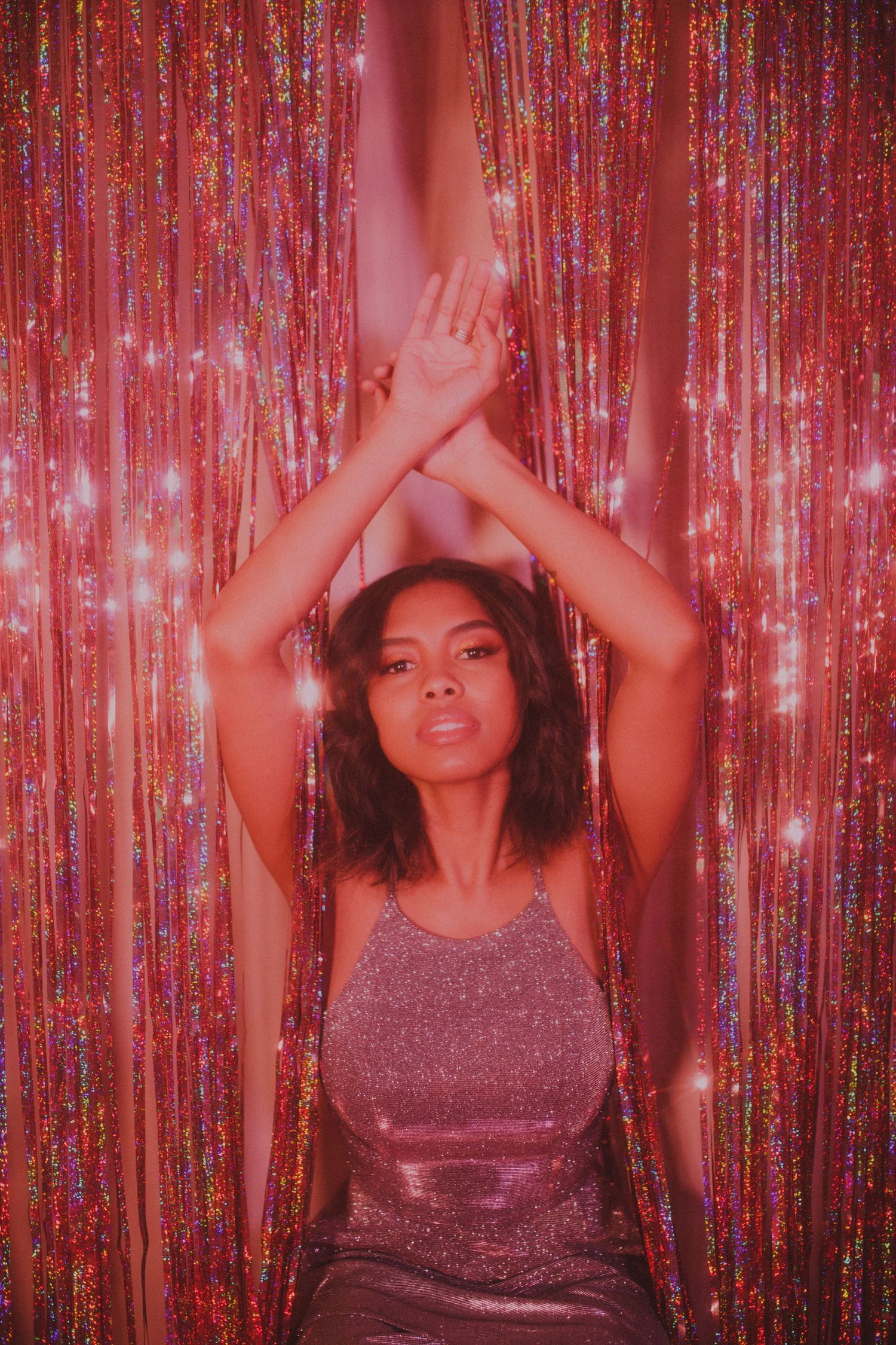 Dance-inspired portrait against shimmering pink metallic curtain backdrop.
