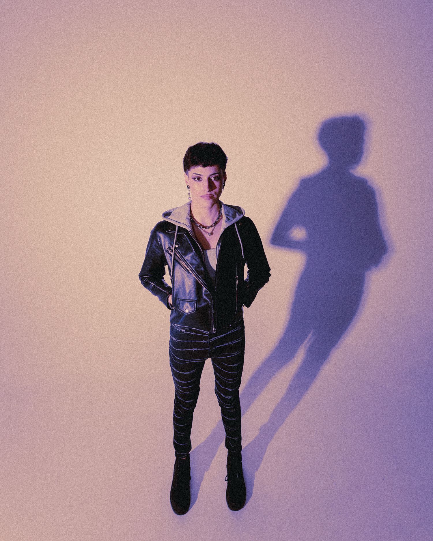 Artistic portrait with purple lighting and dramatic shadow effects.