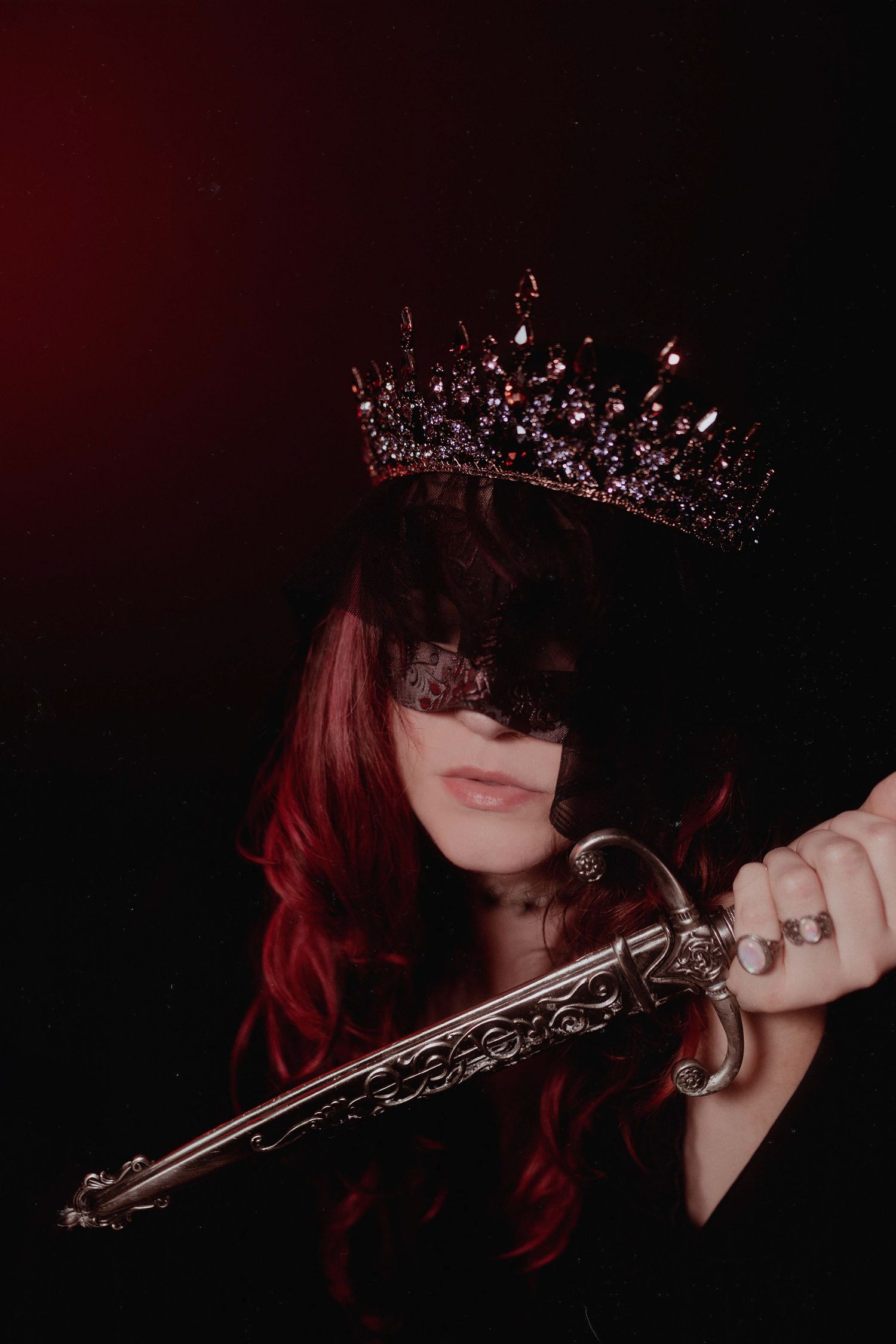 Dark dramatic photos featuring crown and antique pistol with red lighting.