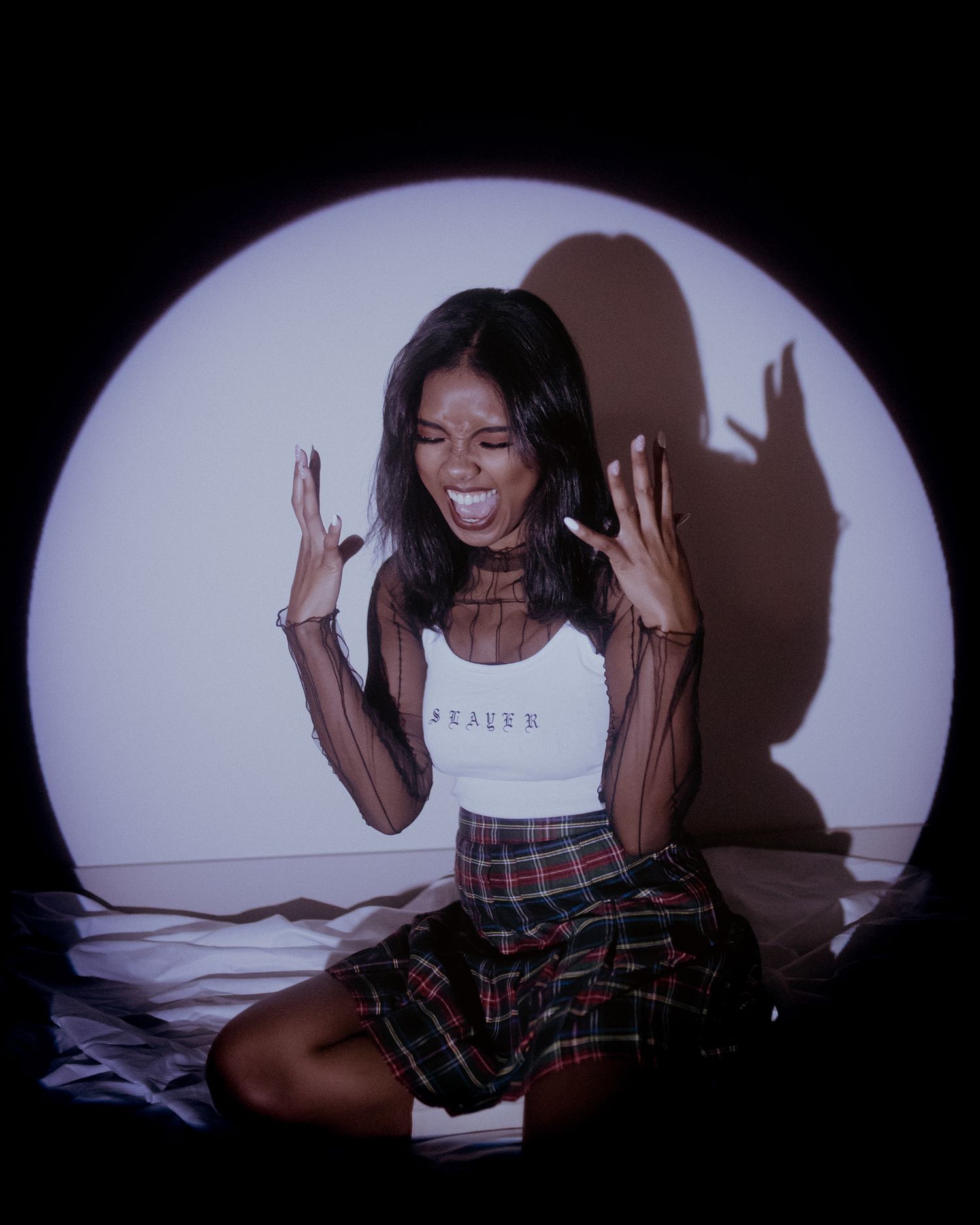 Expressive portrait in spotlight against dark background showing joyful movement.