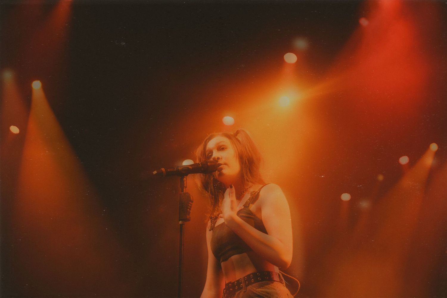 Stage bathed in warm orange lighting during live musical performance.