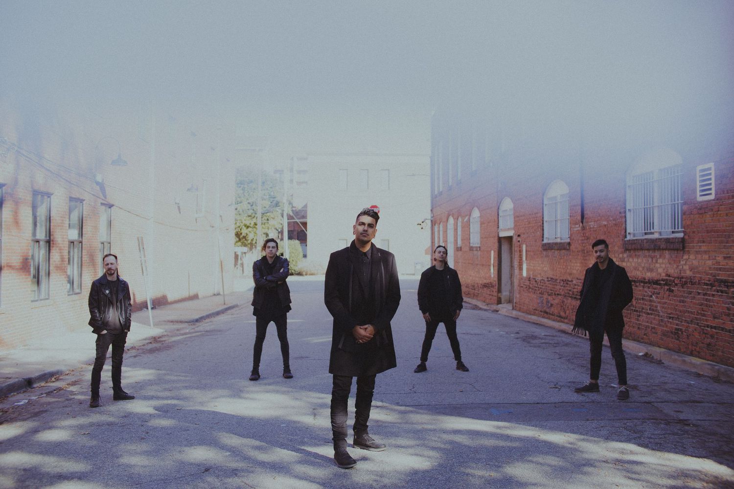 Group of people standing in a misty outdoor setting creating an atmospheric scene.
