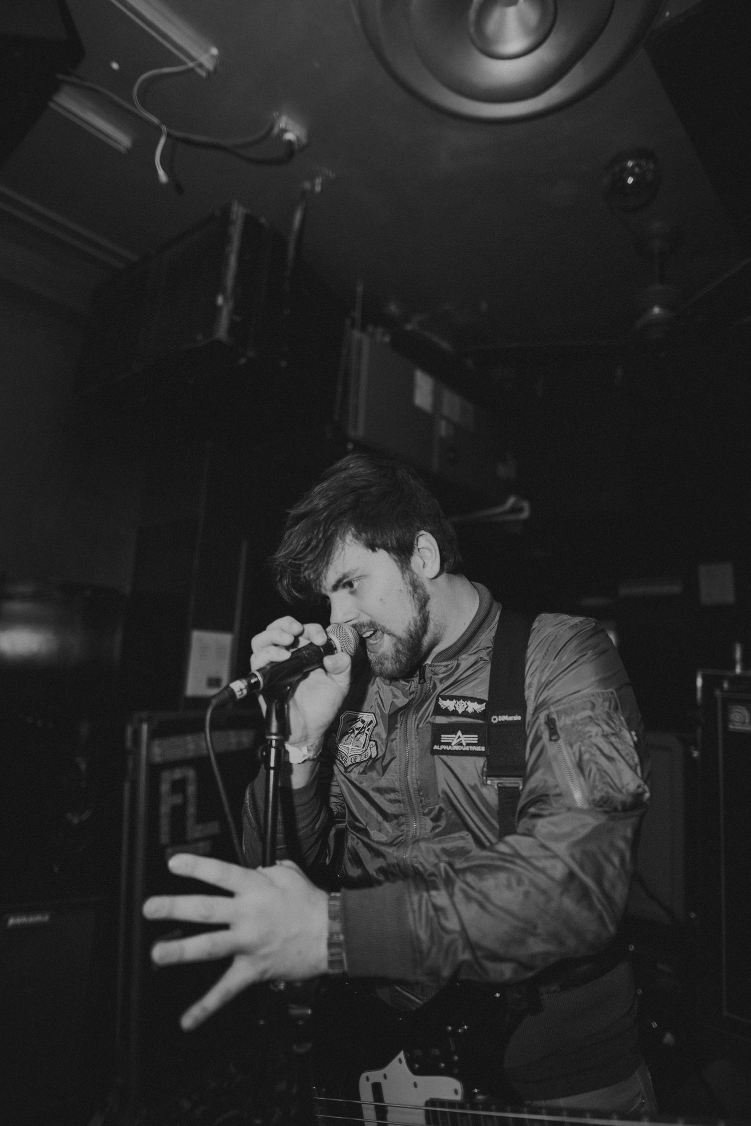 Energetic performer gesturing passionately on stage during an intimate venue performance.