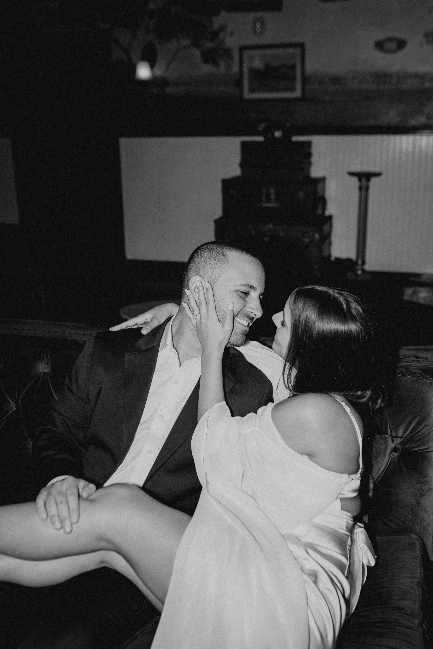 A couple embraces in a playful dance sequence shown in black and white photography.