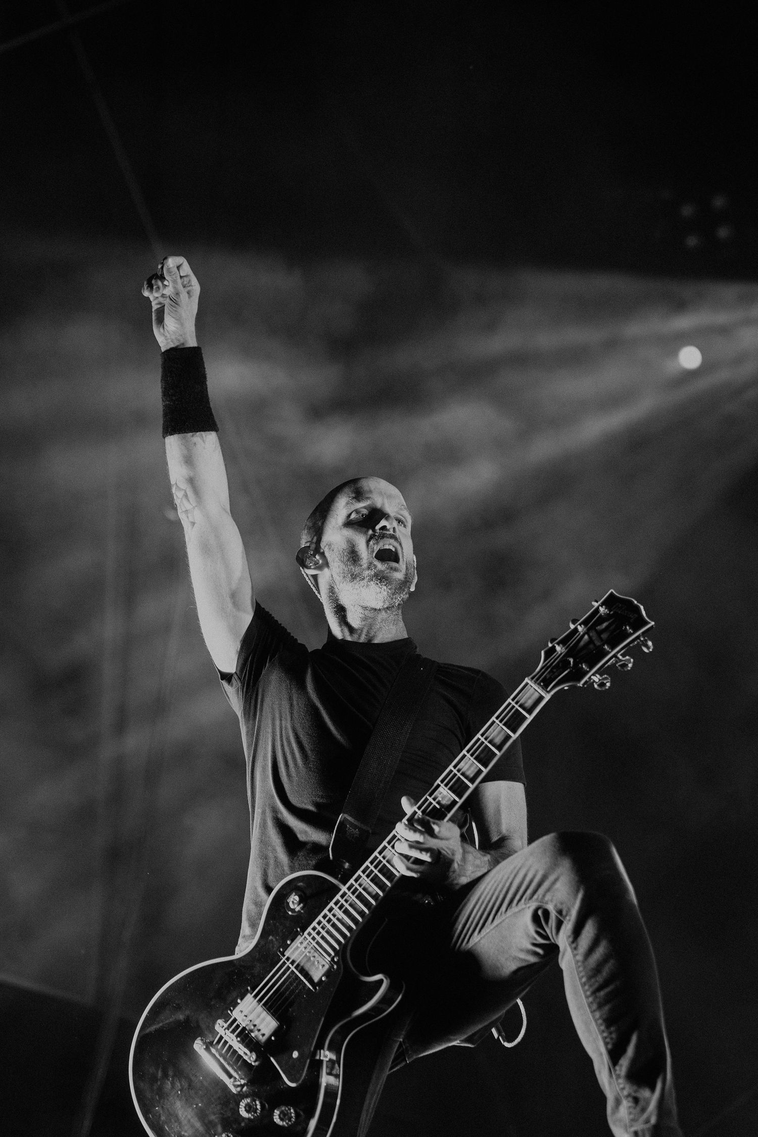 Dramatic black and white shot of guitarist performing passionately on stage.