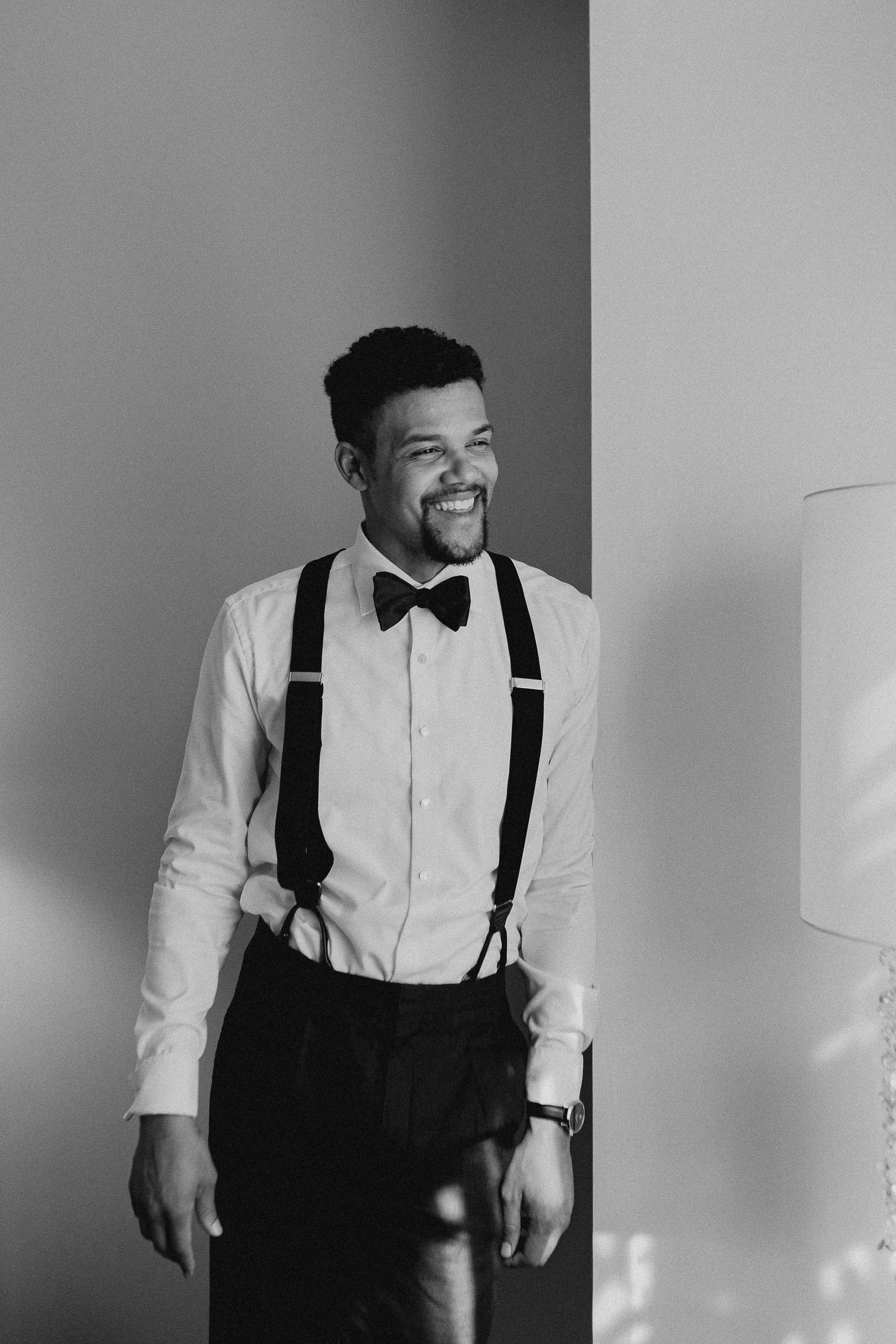 A black and white photo sequence shows a person in formal attire with suspenders and bow tie laughing joyfully.