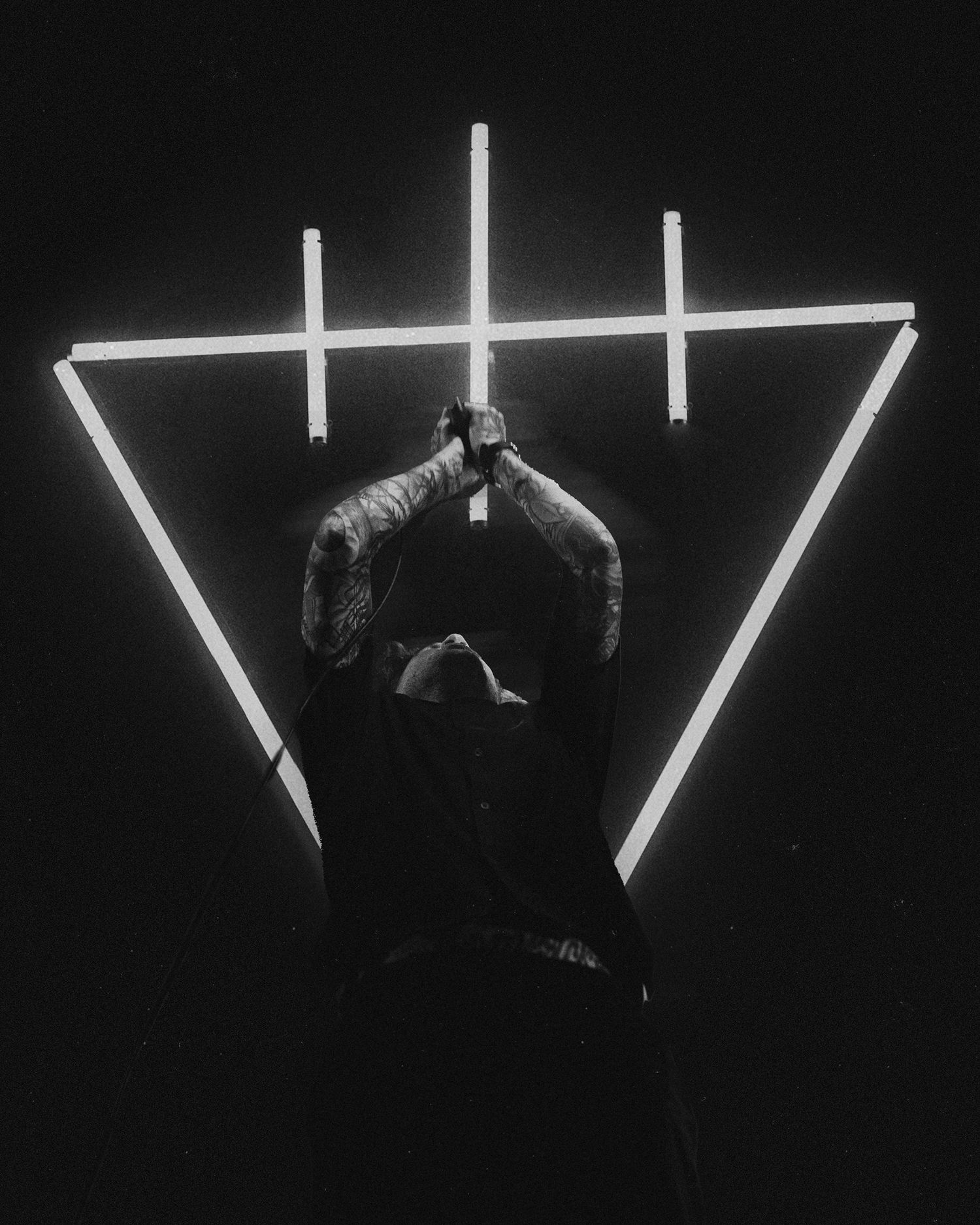 Minimalist stage design featuring geometric light bars against dark background.