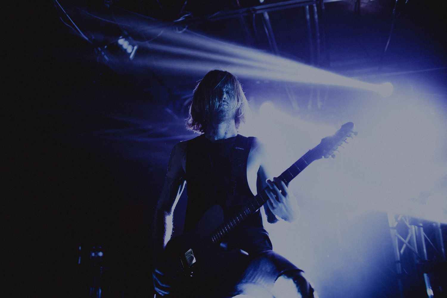 Concert performance captured in blue tones with dramatic lighting effects and silhouetted figures.