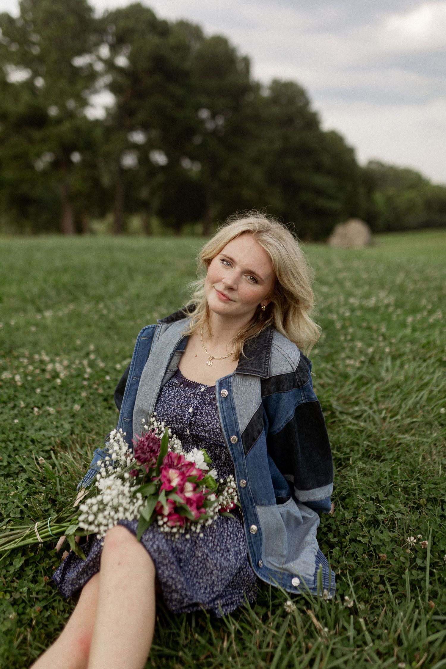 Casual outdoor portrait session in flowering meadow with denim jacket styling.