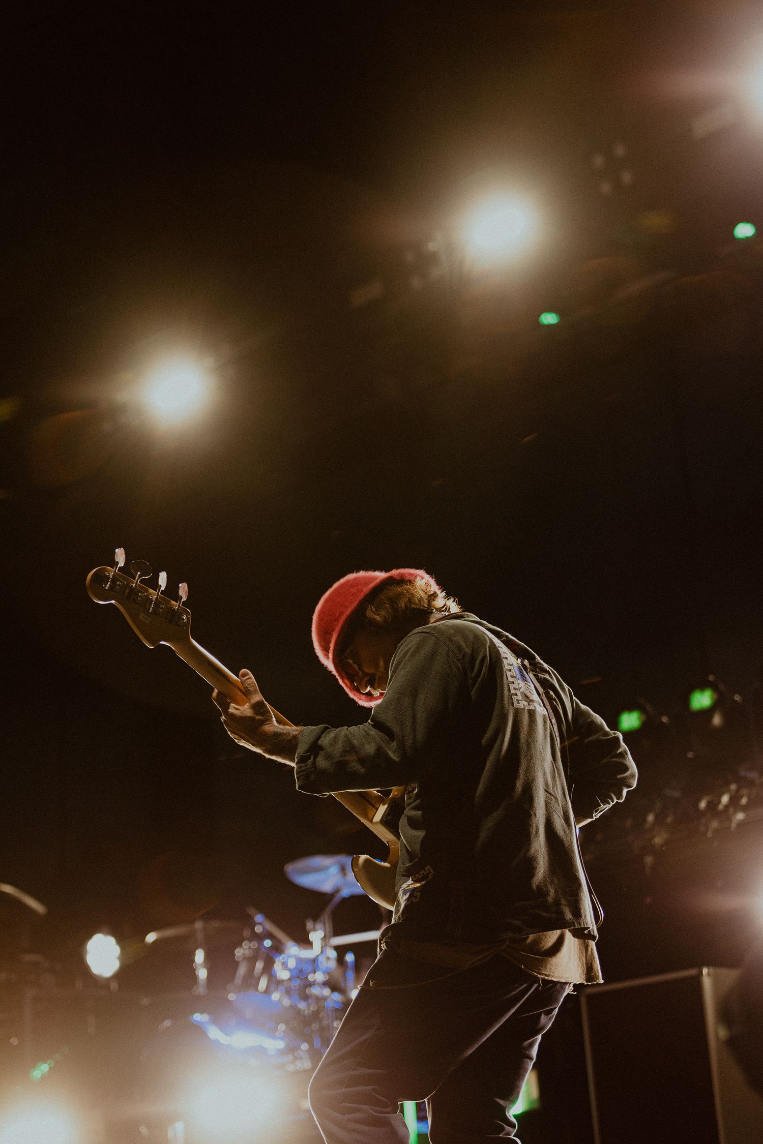 A performer silhouetted against dramatic stage lighting during an energetic concert performance.