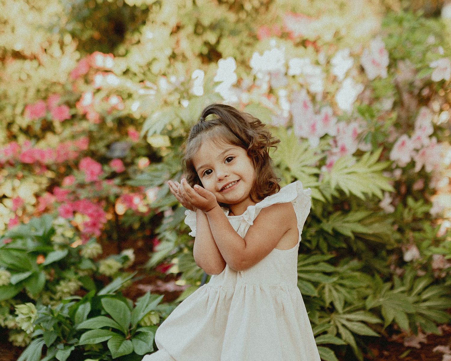 Playful moments captured in a lush garden setting with blooming flowers.