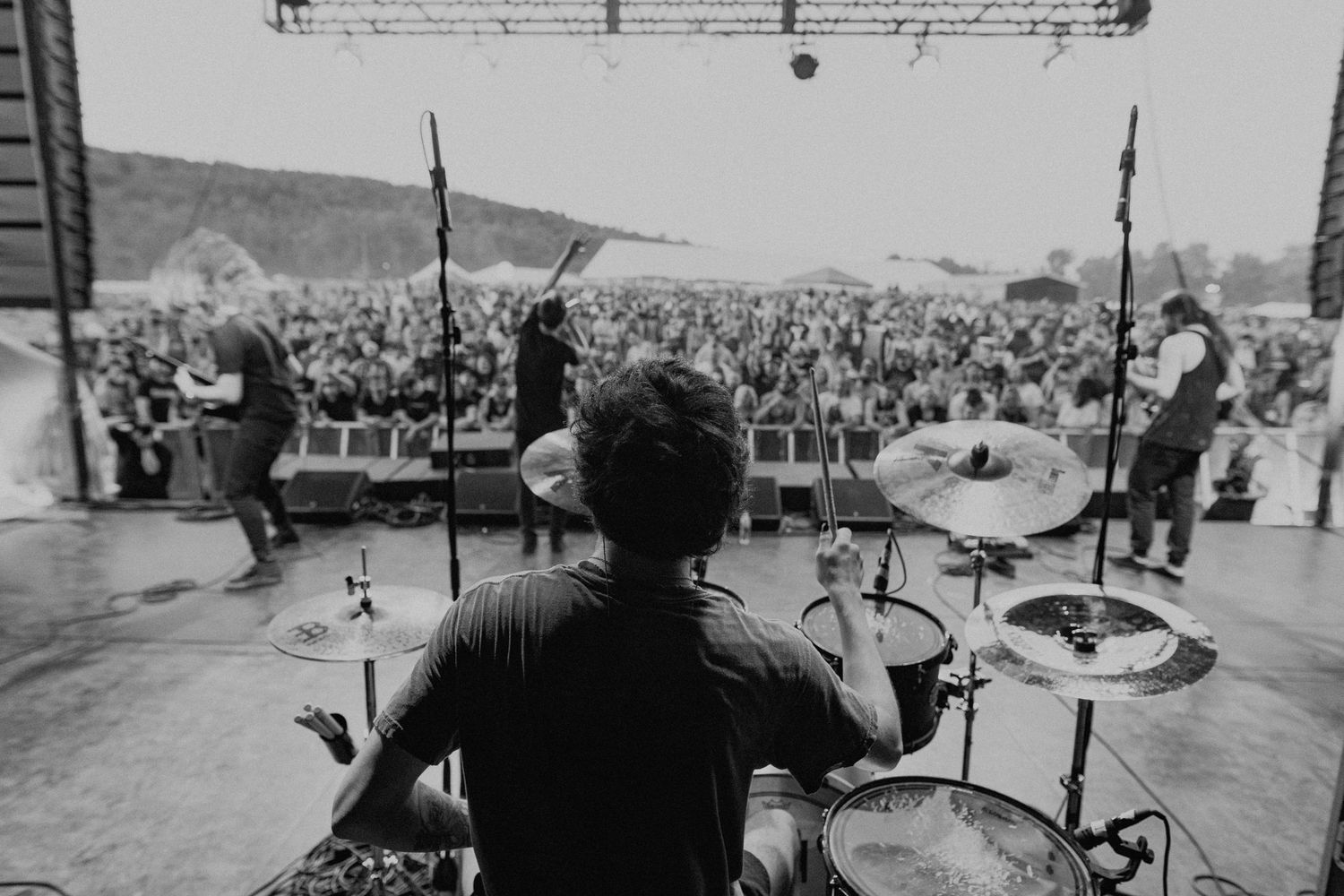 Wide angle view of outdoor concert venue with mountains visible in background.