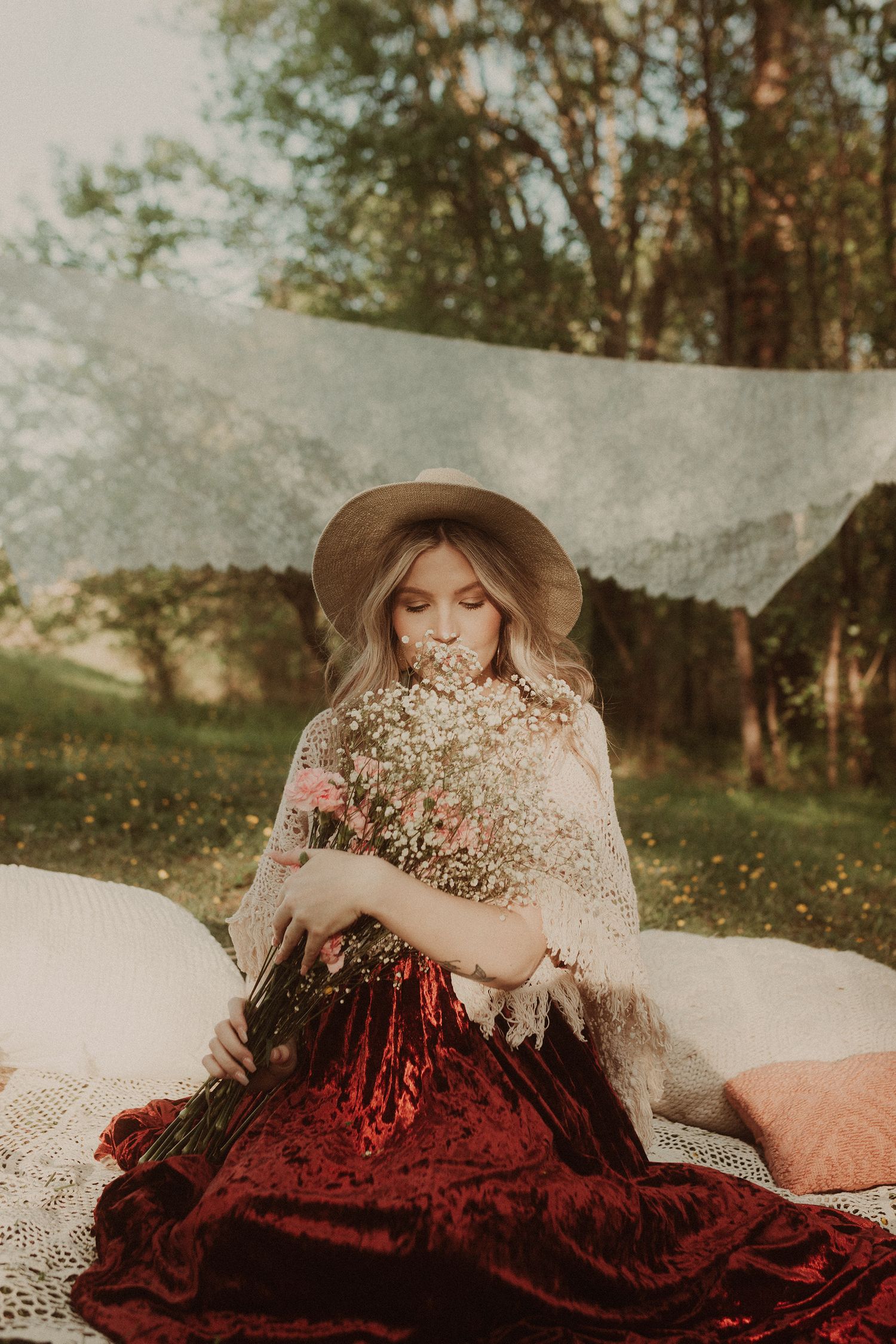 Dreamy outdoor photoshoot featuring burgundy dress and baby's breath flowers.