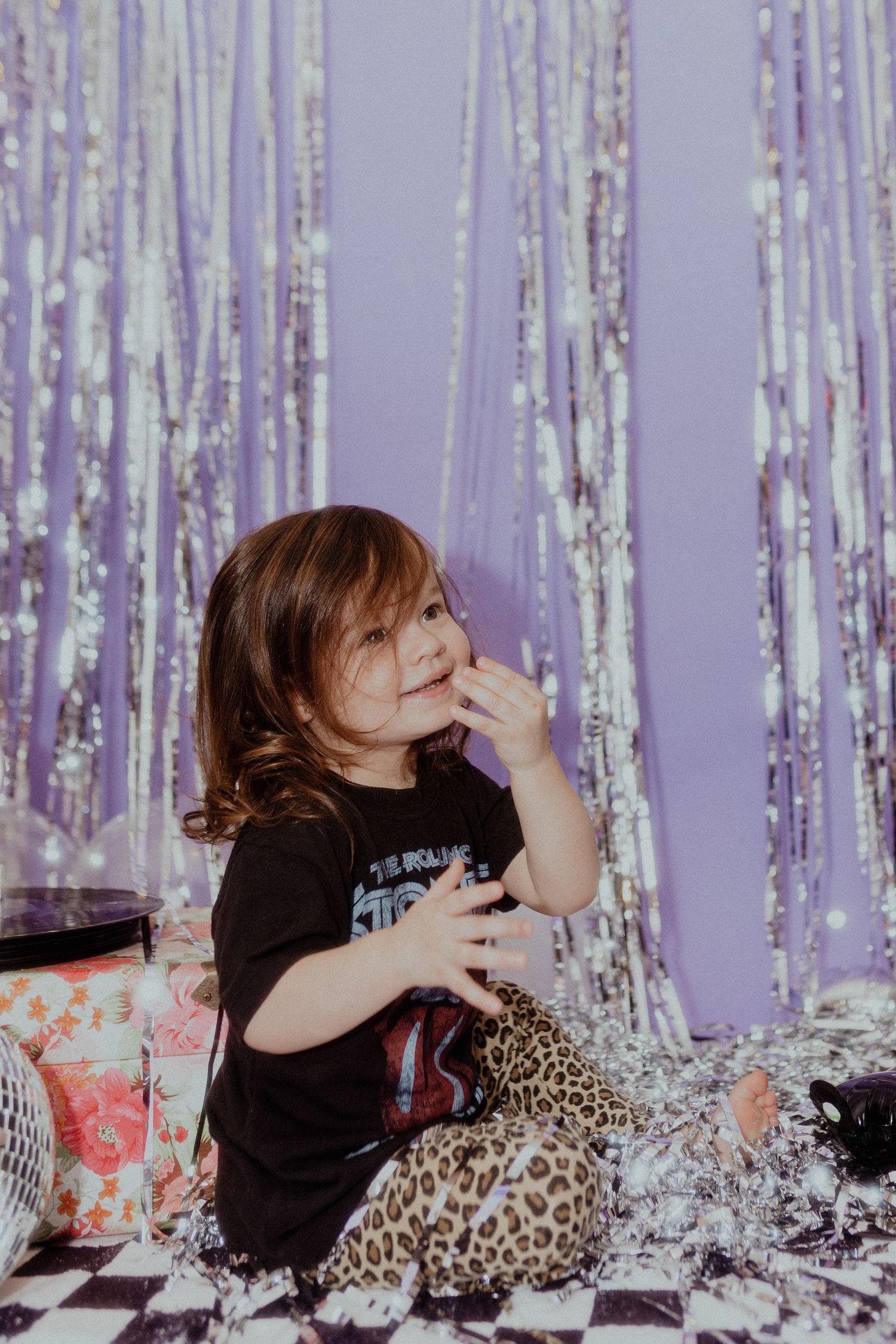Fun portrait session with leopard print pillows and silver tinsel decorations.