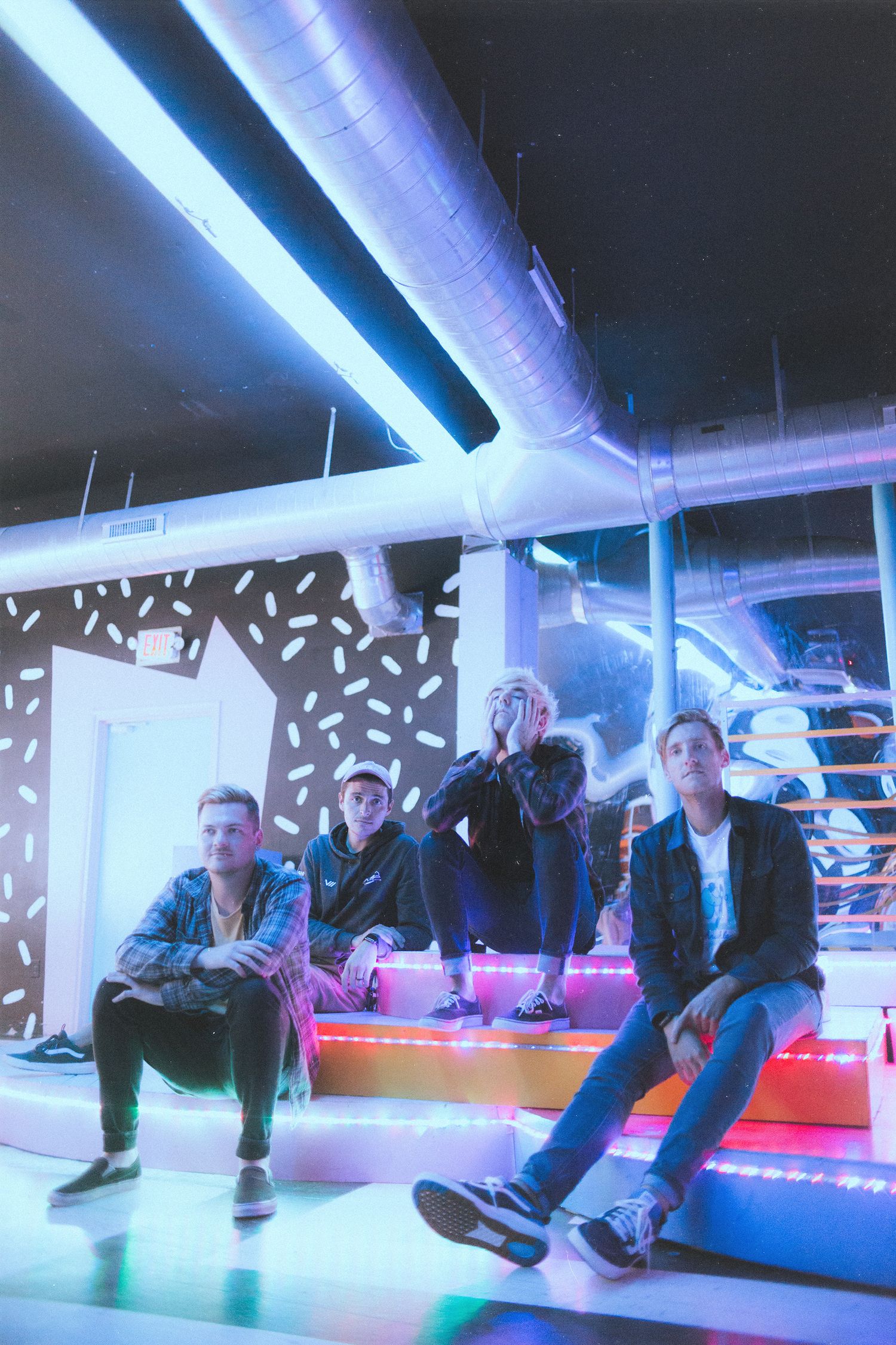People lounging under blue fluorescent lighting in an indoor space.