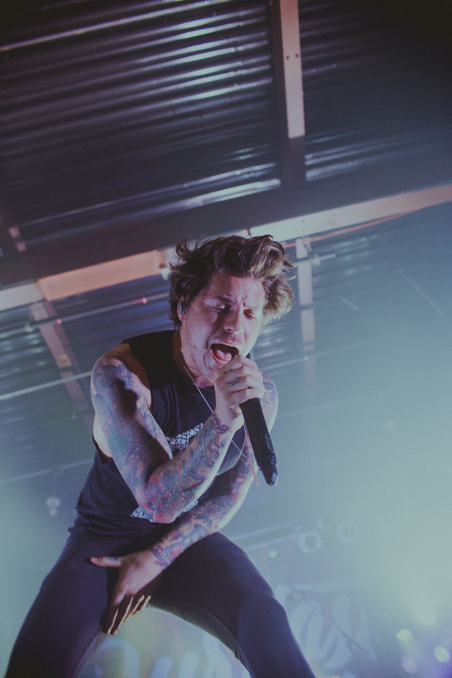 Dynamic concert performance with dramatic backlighting and energetic stage presence.