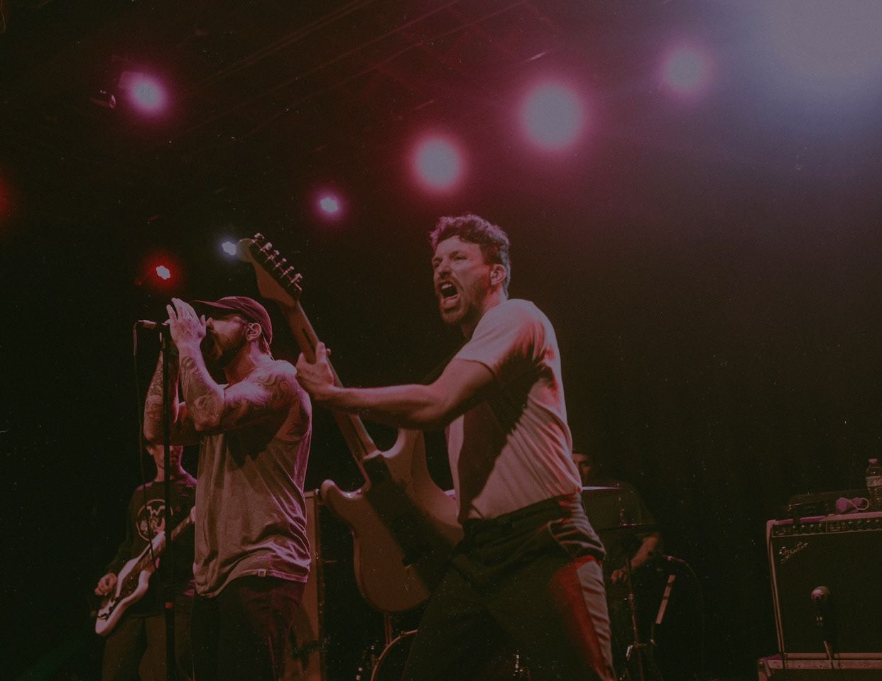 Live music performance with performers interacting energetically on stage.