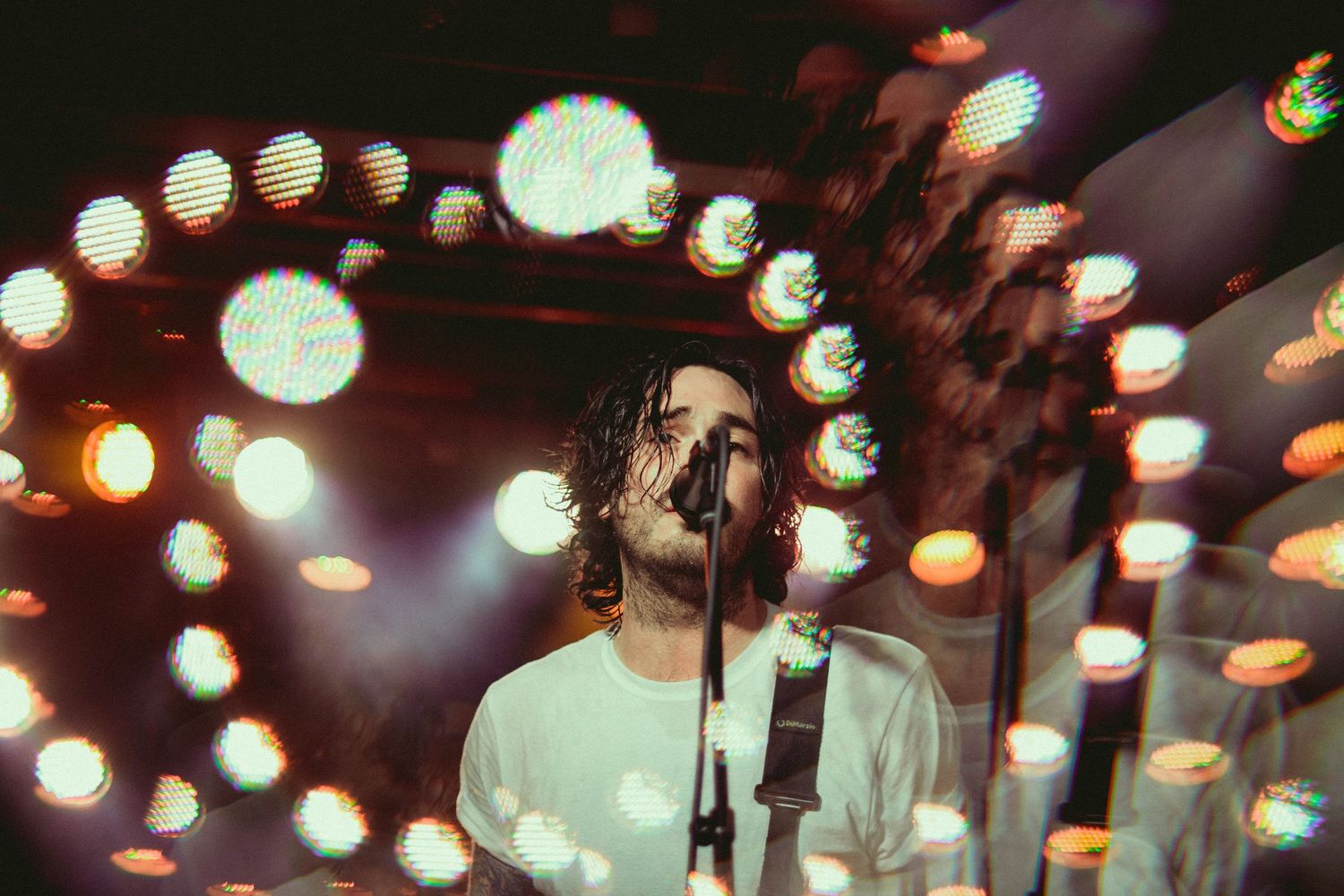 Concert venue with hanging decorative lights creating atmospheric bokeh effect.