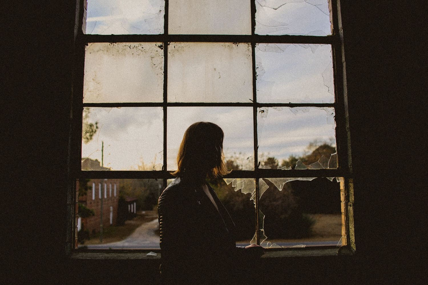 Silhouette against window panes at sunset.