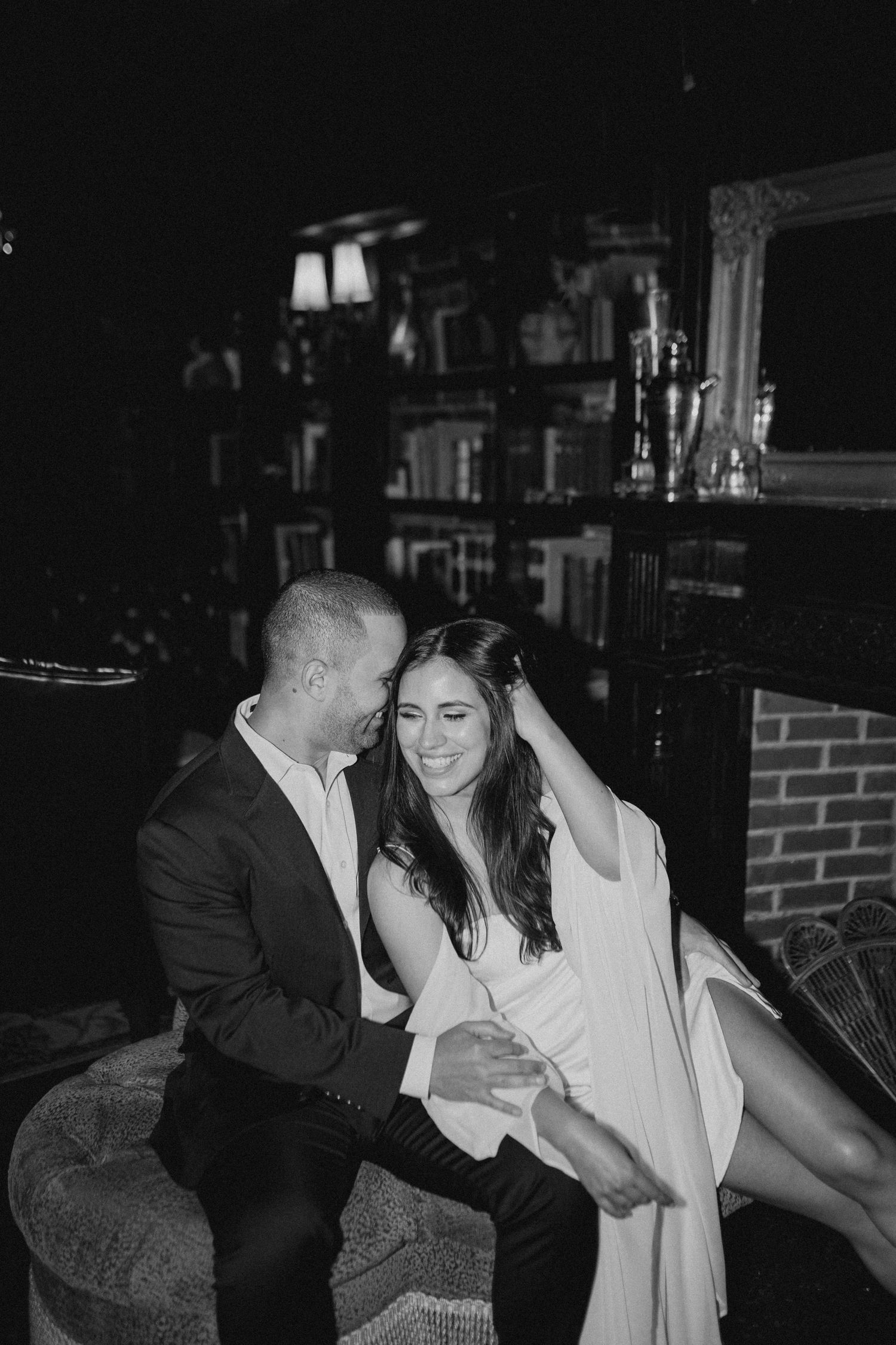 Intimate black and white photo of couple sharing tender moment on couch.