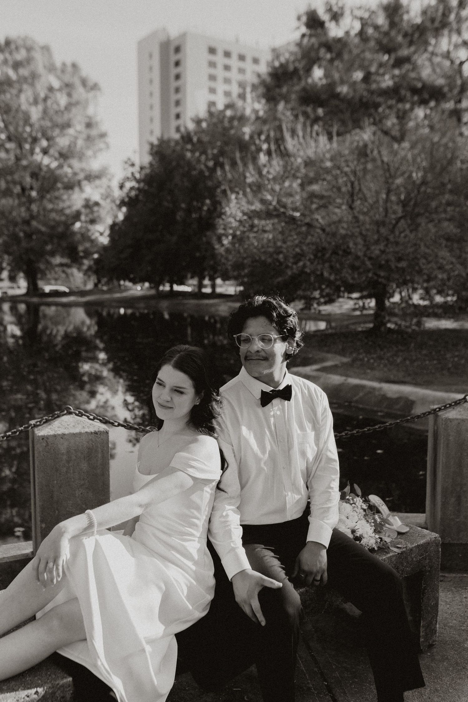 Black and white wedding portraits taken on an urban bench with classic styling.