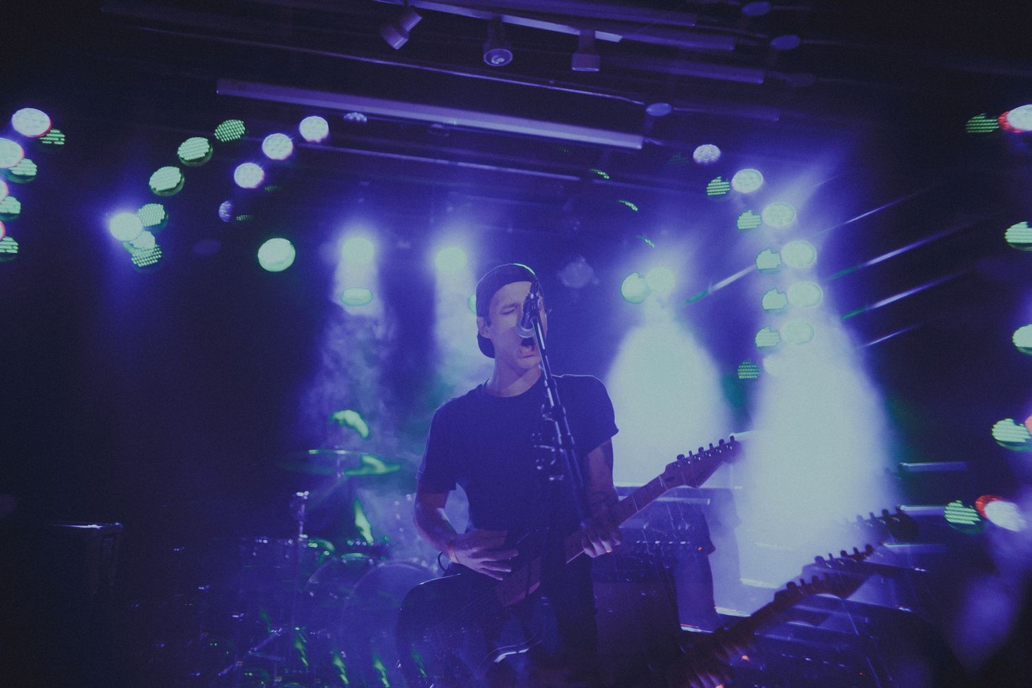 Rock concert with atmospheric blue lighting and silhouetted performers creating an intense mood.