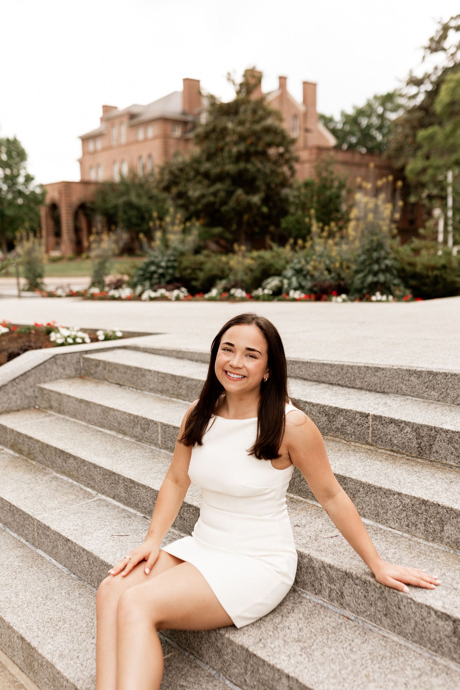 White dress on concrete steps with brick building in background.