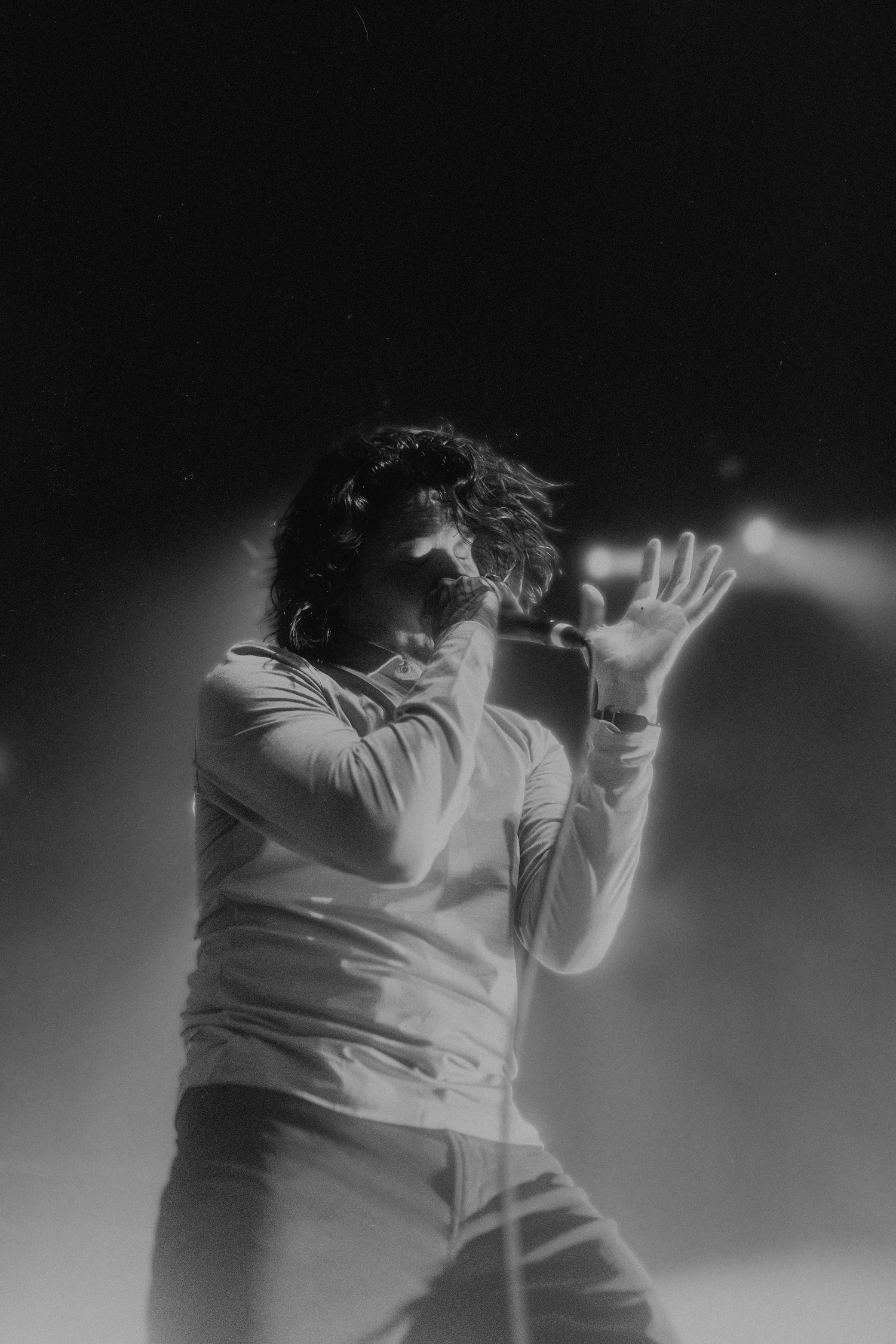 Dramatic monochrome performance shot showing expressive movement on stage.